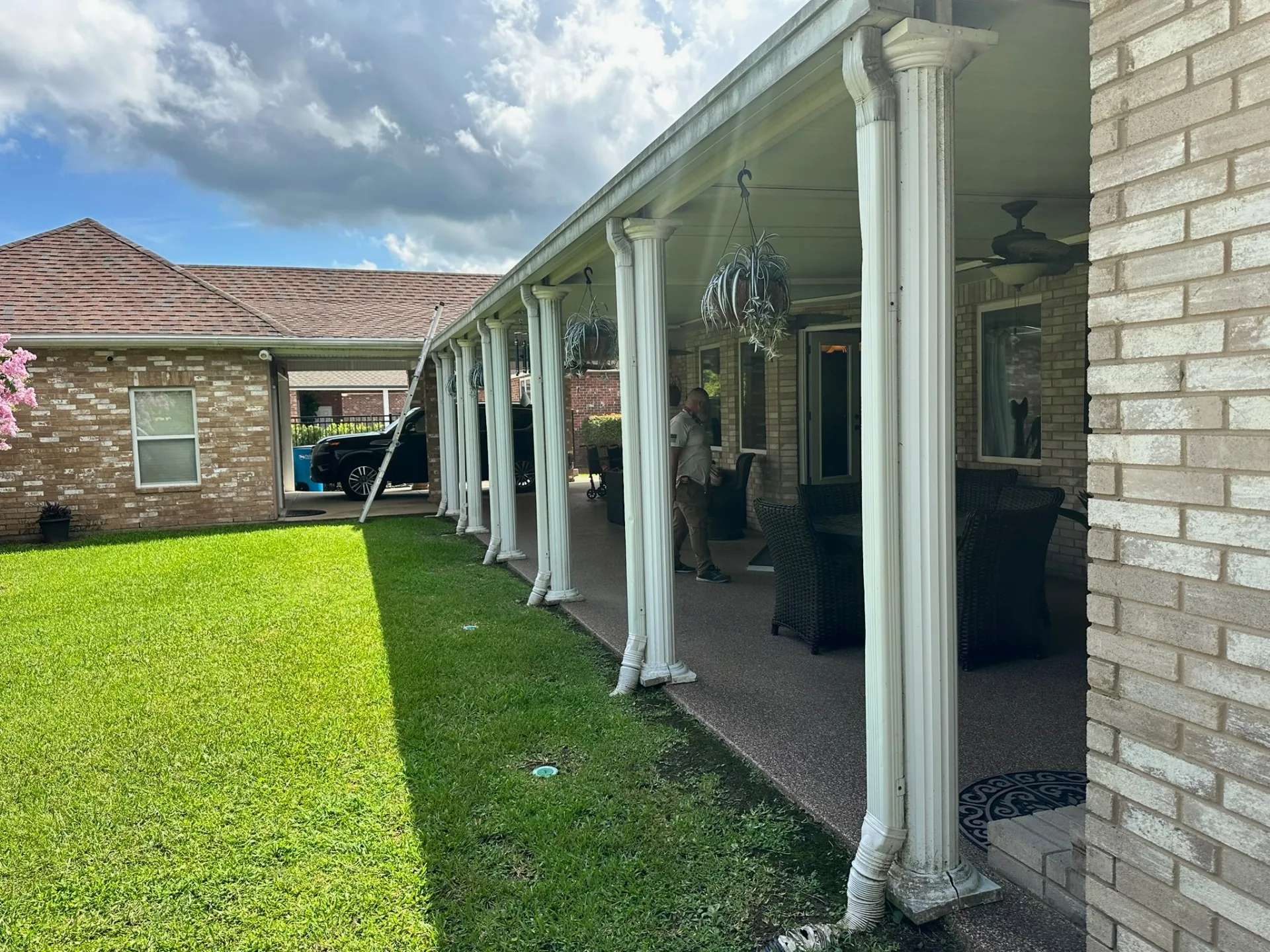 Yard view down the length of the existing covered patio columns at Destrehan Louisiana home before complete rebuild