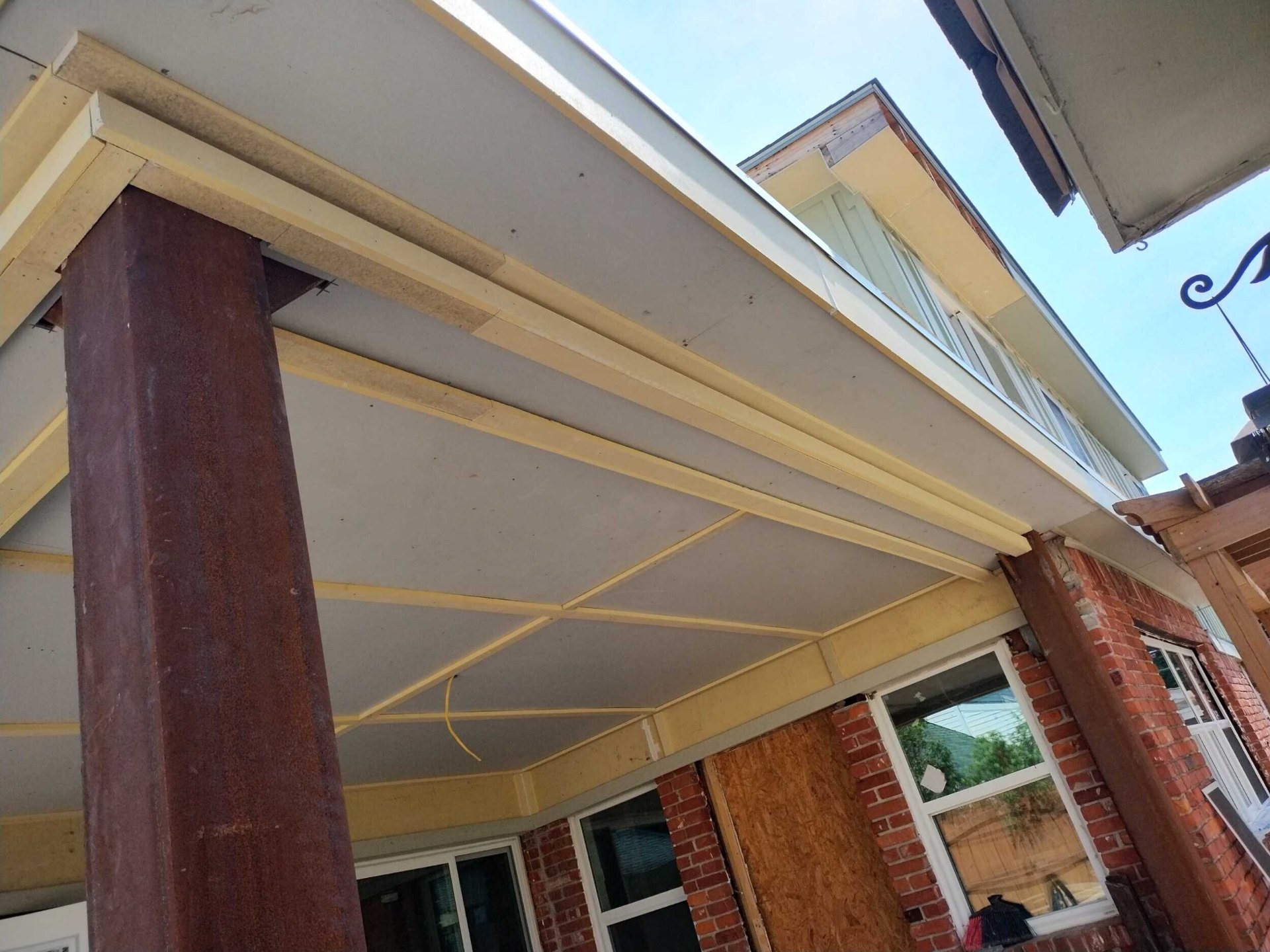 Covered porch soffit and column trim primed during Blanke Street Metairie whole-home remodel exterior phase