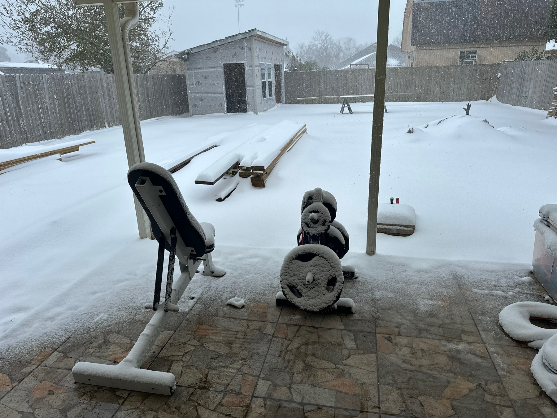 Metairie Hardie-siding shed standing through historic January snowstorm with several inches of snow on flat roof and yard