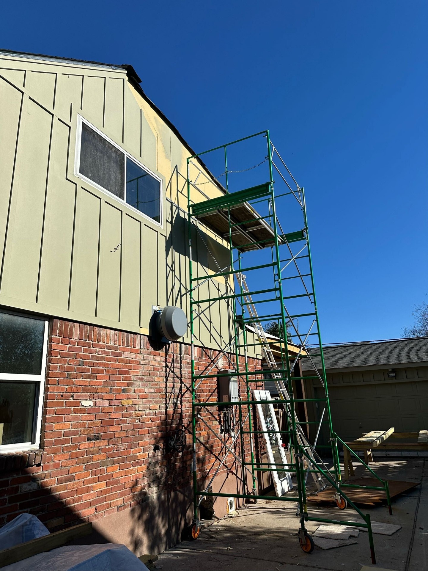 Scaffold set on rear elevation of Blanke Street Metairie home during exterior siding and paint prep on new second story