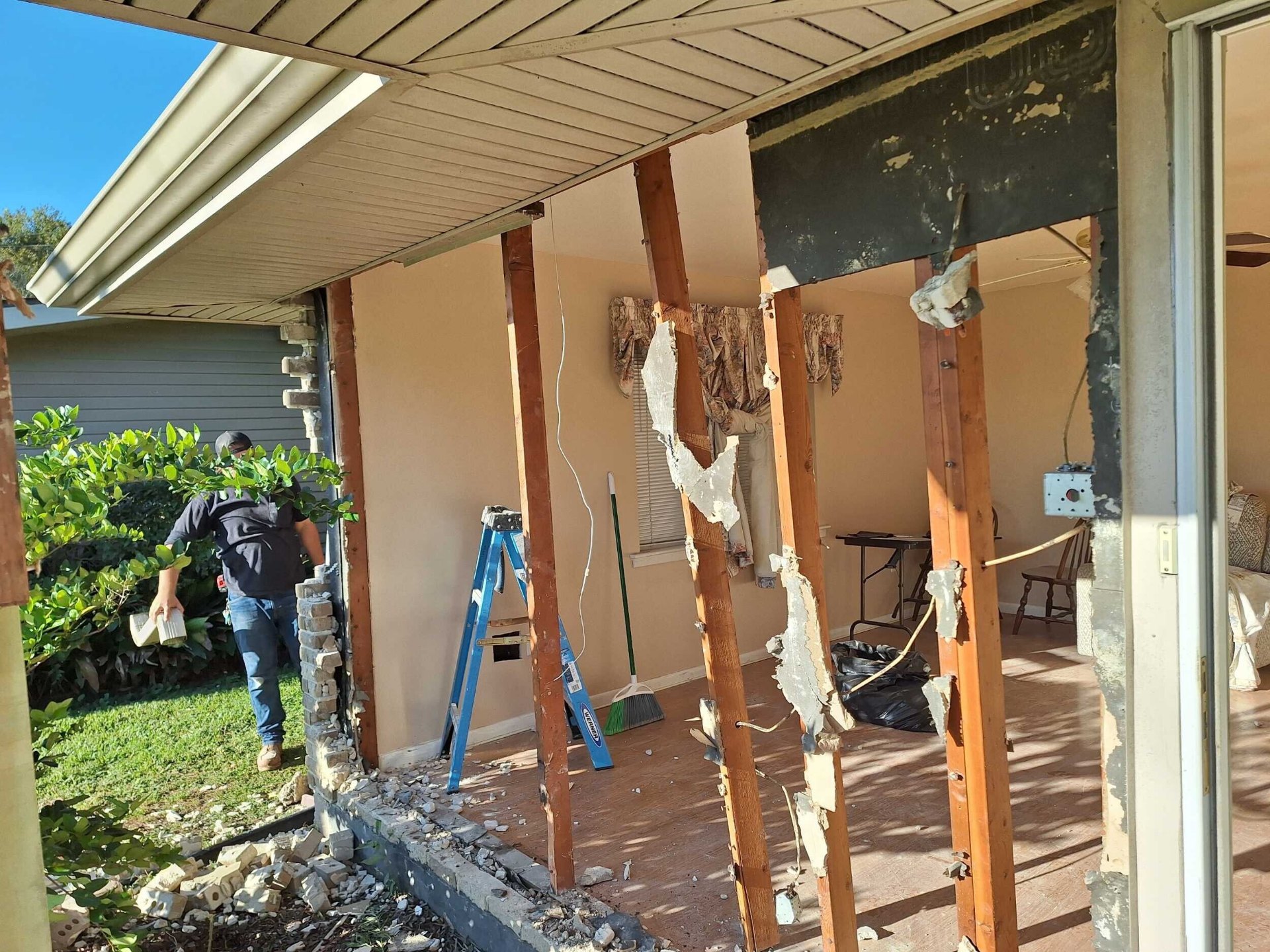 Cajun Home Services crew member removing damaged brick veneer during structural demo on a Gretna insurance repair