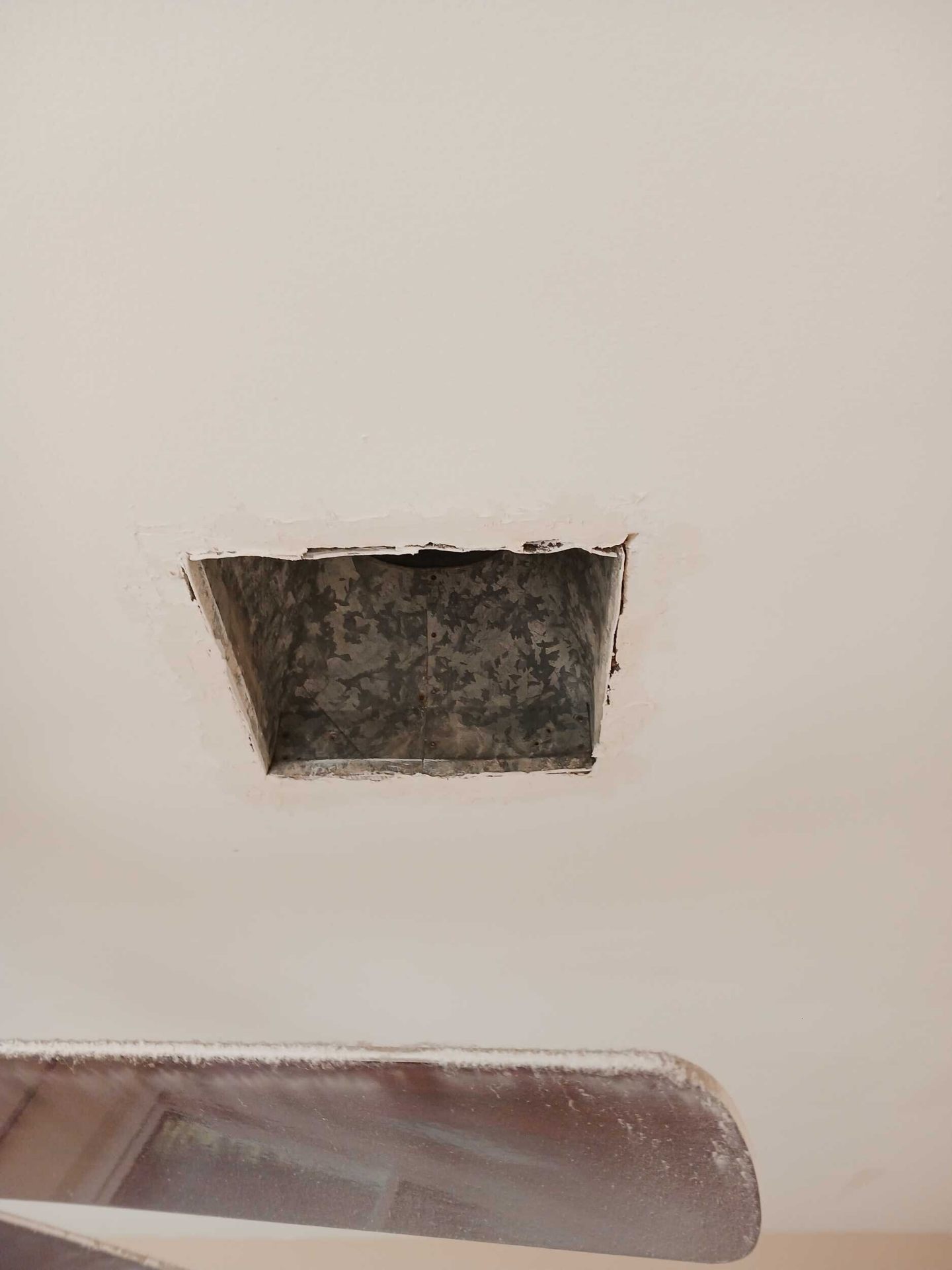 Ceiling HVAC duct boot opened up during the Gretna insurance repair to service the return-air and re-hang drywall trim ring