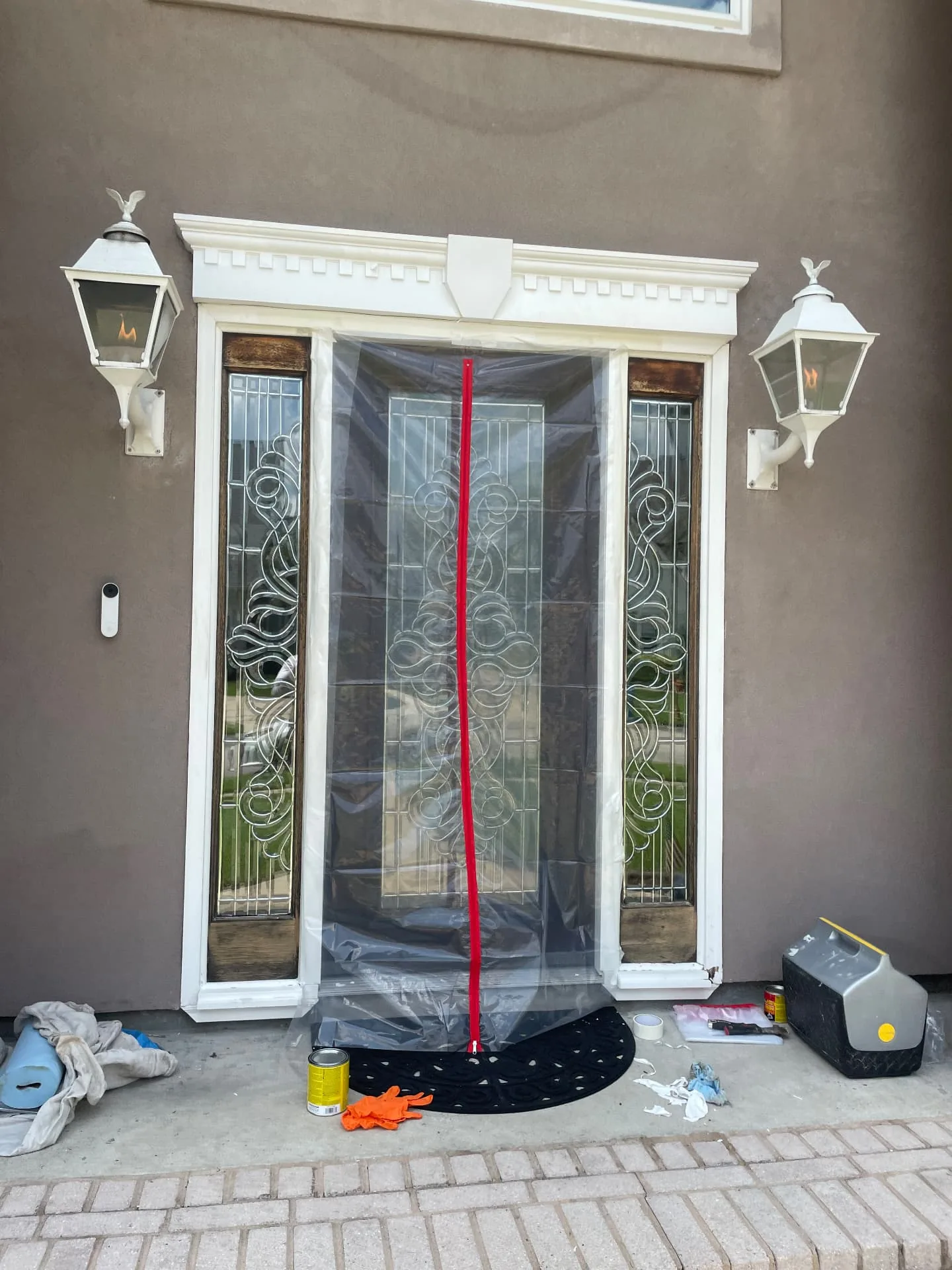 Entry masked with plastic sheeting during trim paint prep in Destrehan