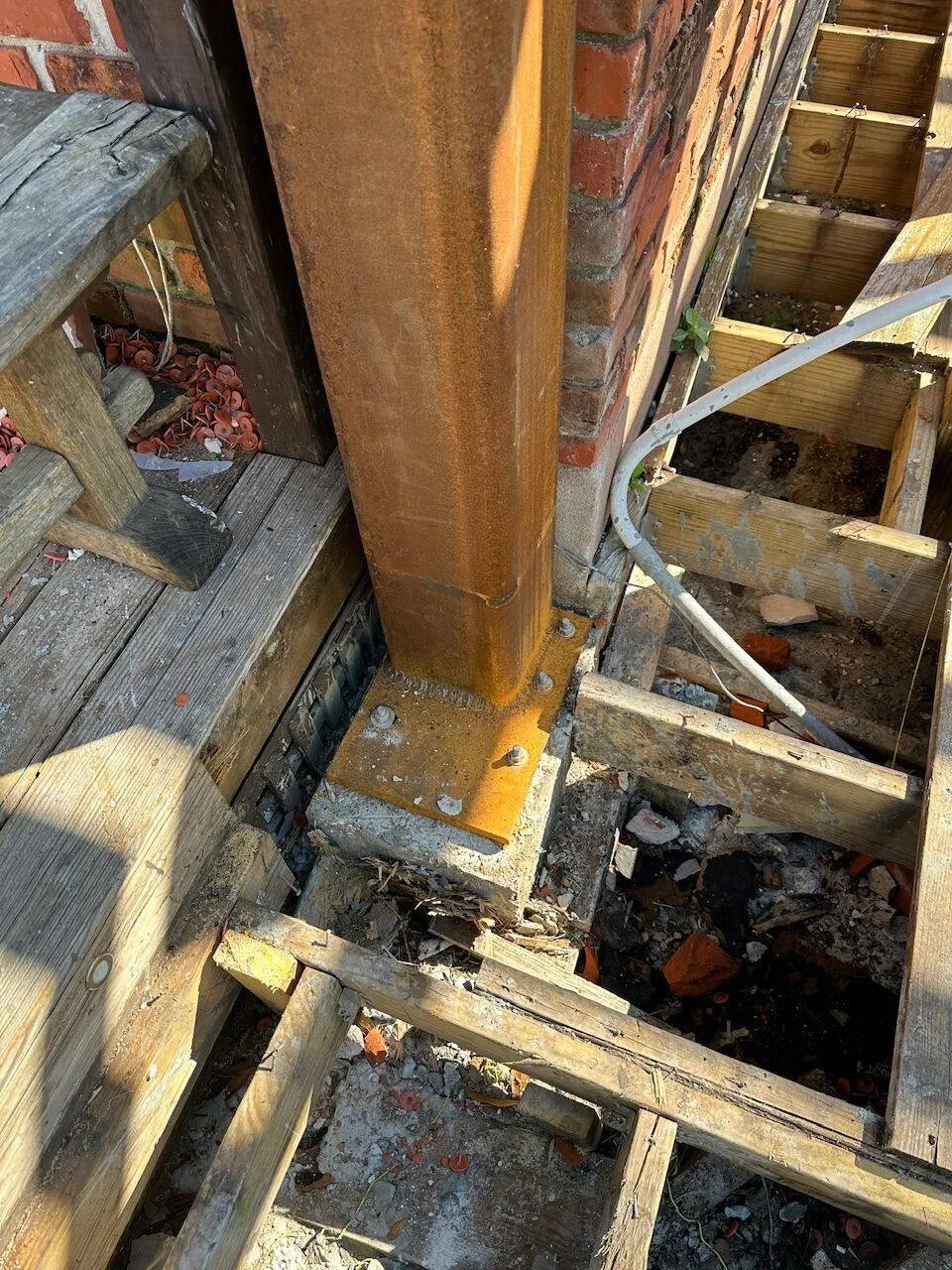 Steel column bolted to base plate on foundation pier for structural support