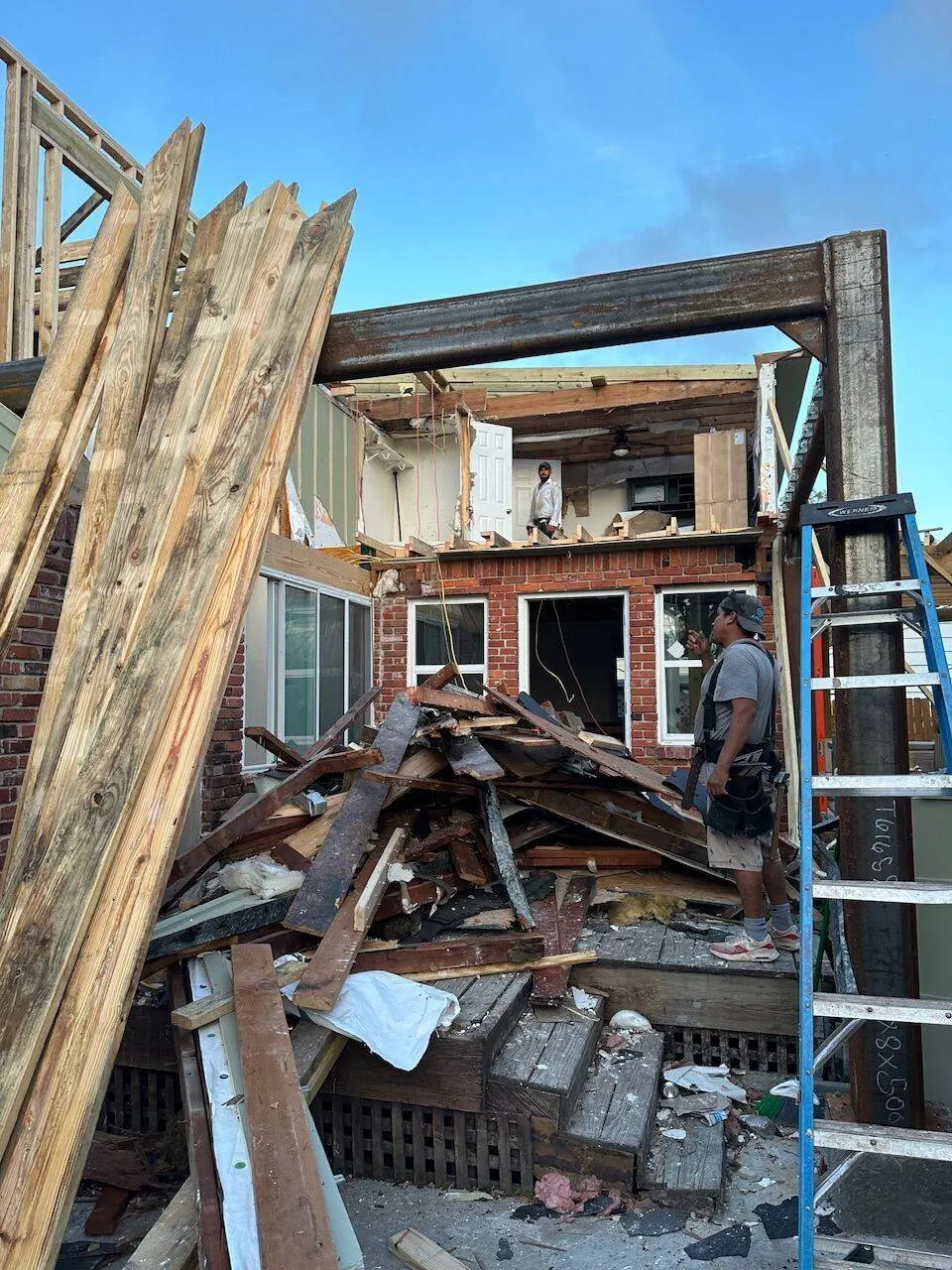 Crew performing major structural demolition and rebuild on two-story home