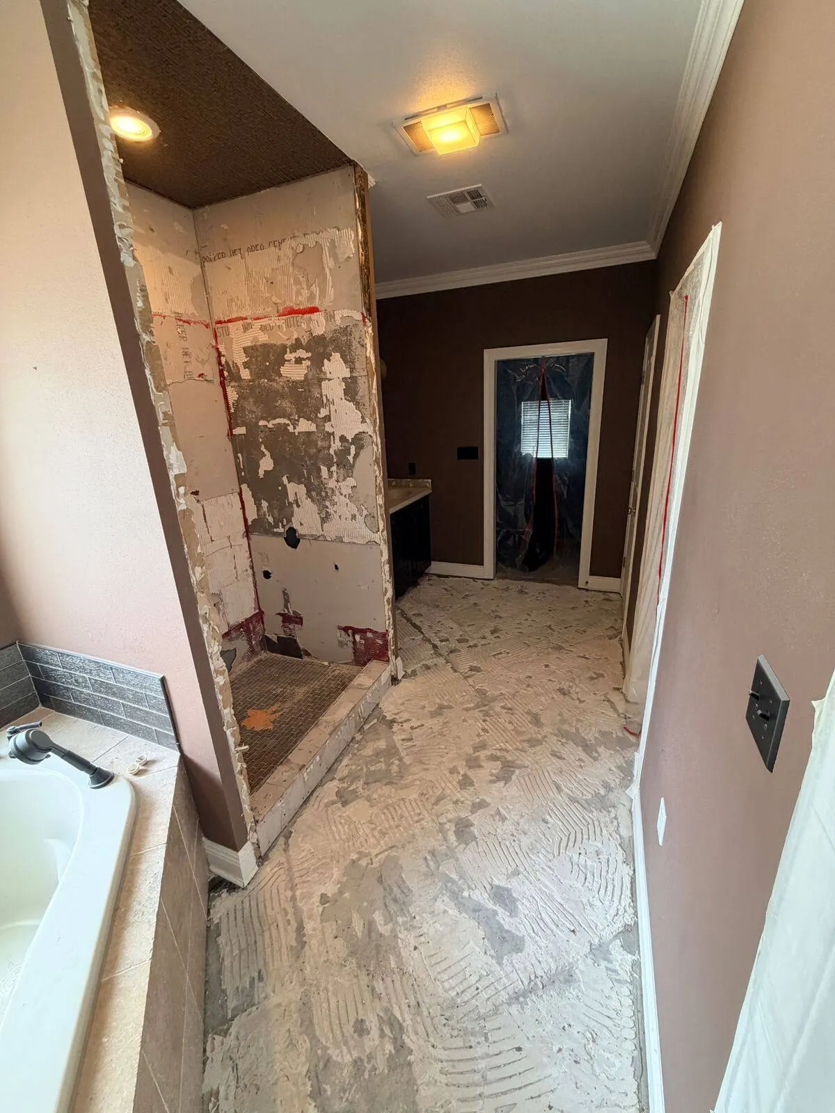 Master bathroom with shower walls removed and floor tile prepped for replacement during full remodel in Destrehan Louisiana