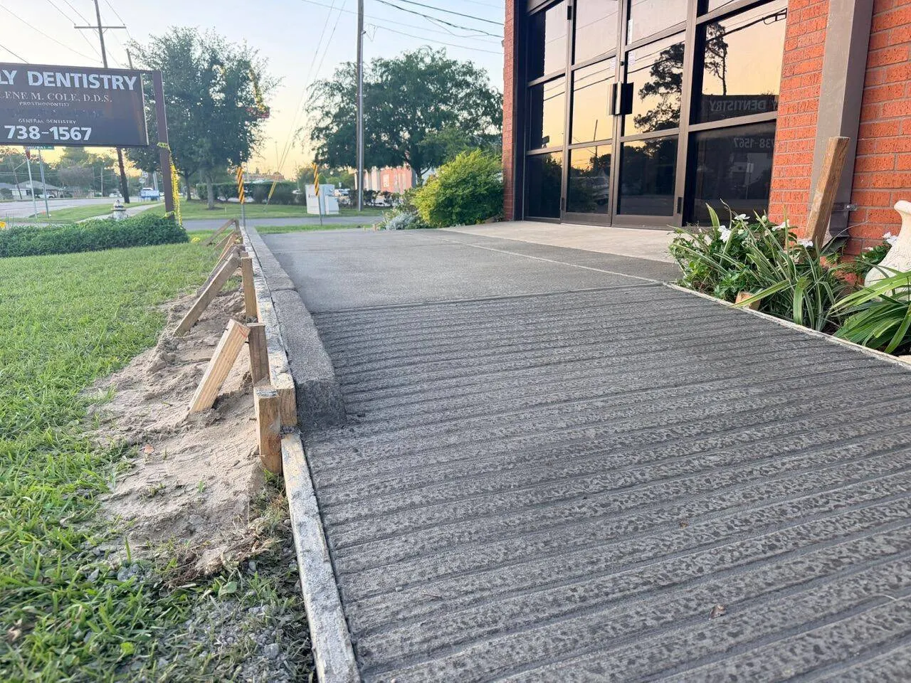 Freshly poured commercial concrete sidewalk with broom finish in front of dentistry office in River Ridge Louisiana Jefferson Parish