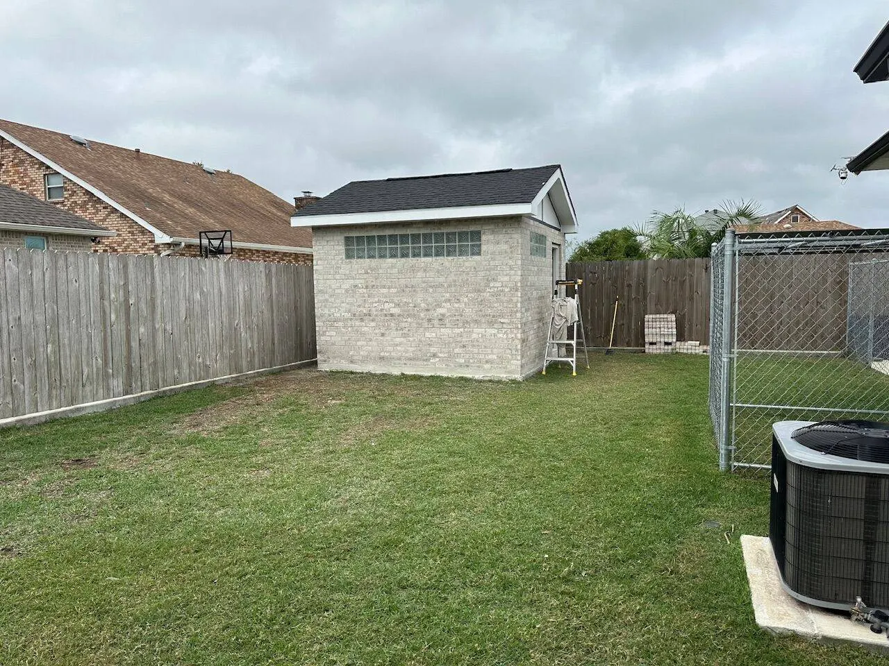 Completed block outbuilding with new shingle roof and glass block windows in Metairie Louisiana