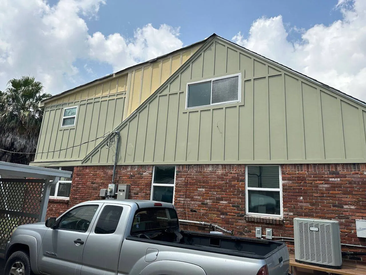 Completed second story addition with board and batten siding on brick home in New Orleans area