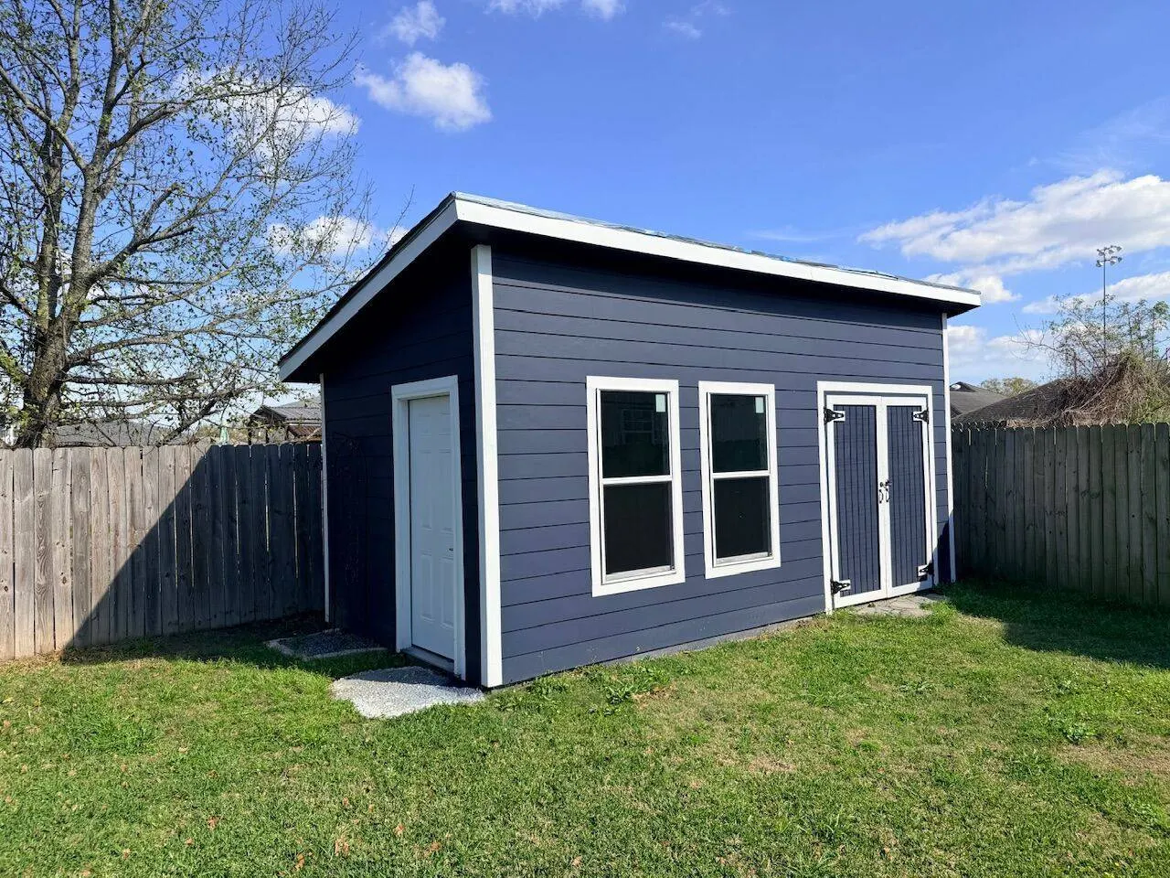 Custom navy Hardie-siding outbuilding built in Metairie Louisiana backyard