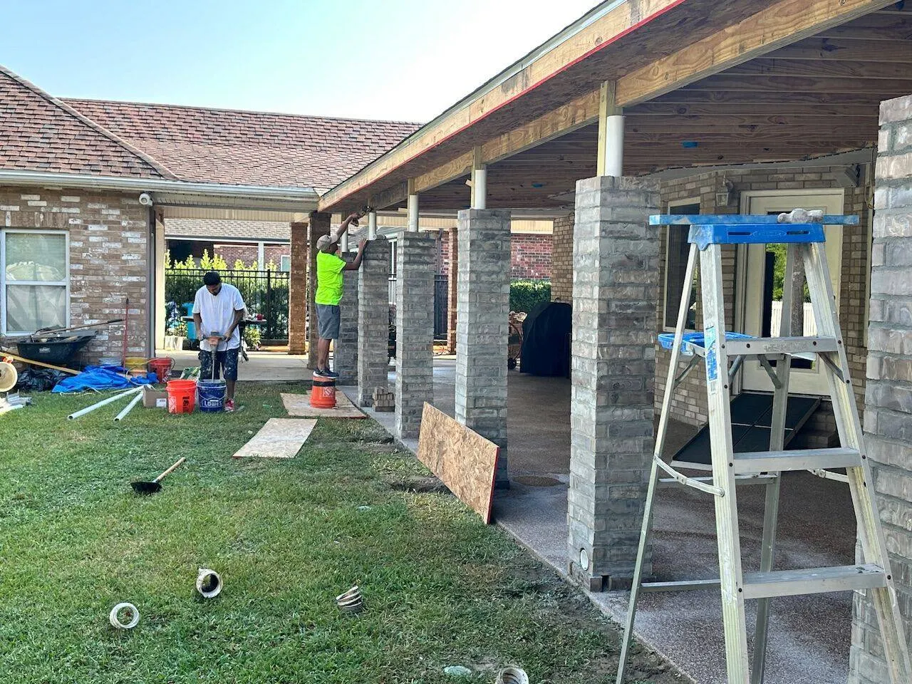 Cajun Home Services crew building covered patio with brick columns and wood framing in Louisiana