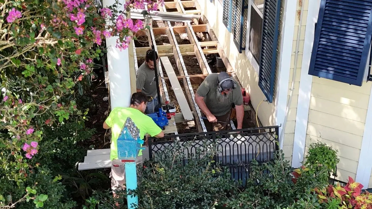 Crew reframing porch and installing composite decking on residential home in Algiers LA
