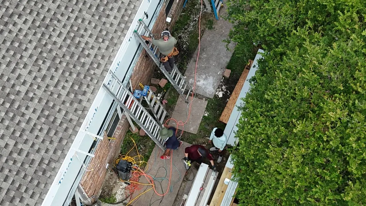 Crew installing Hardie plank siding on second floor addition in Metairie Louisiana