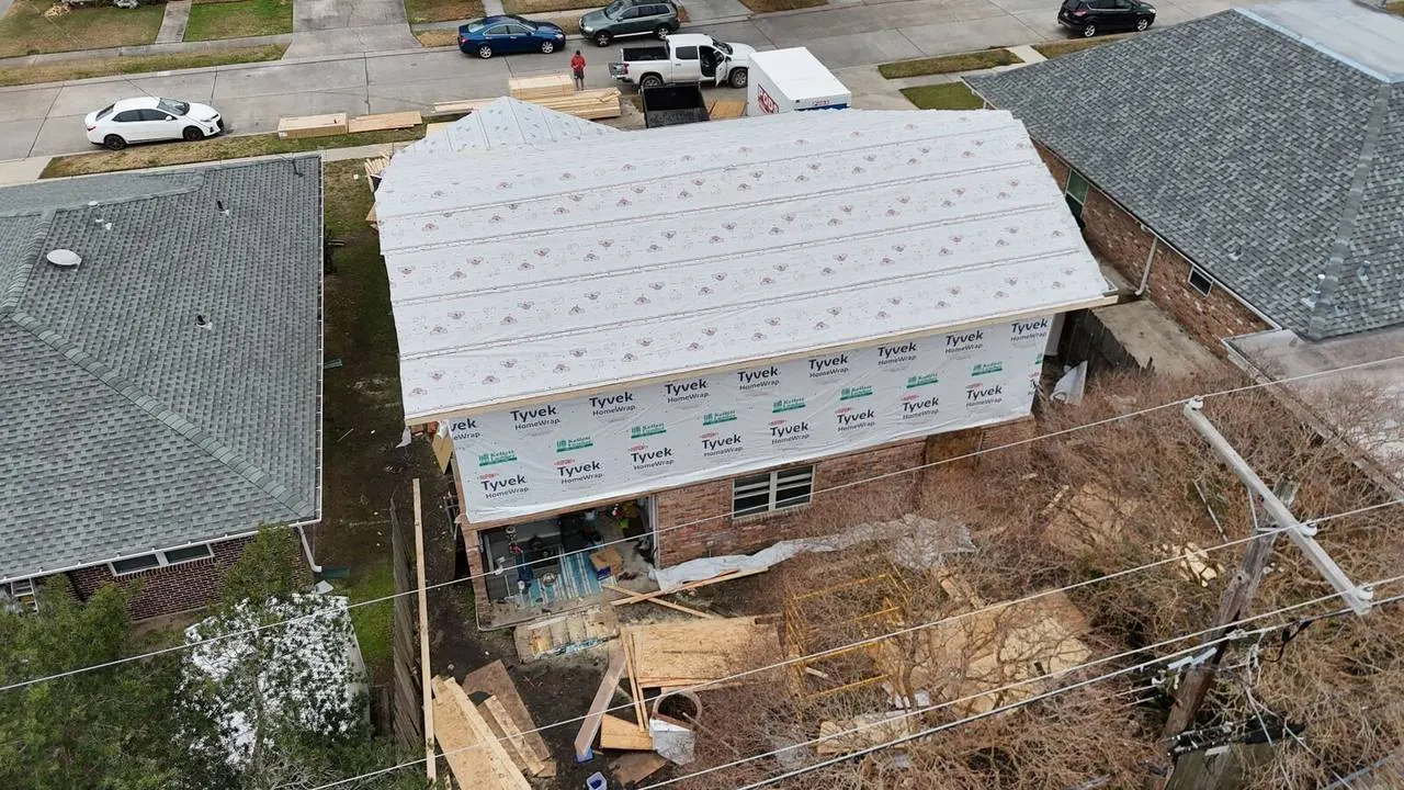 Front aerial of Tyvek HomeWrap on second floor addition with materials staged in Metairie