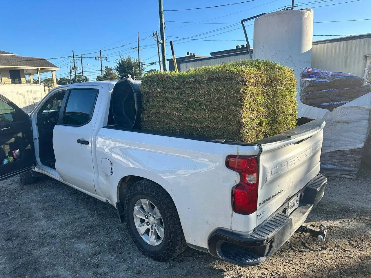Cajun Home Services work truck loaded with sod pallets at supply yard in Southeast Louisiana