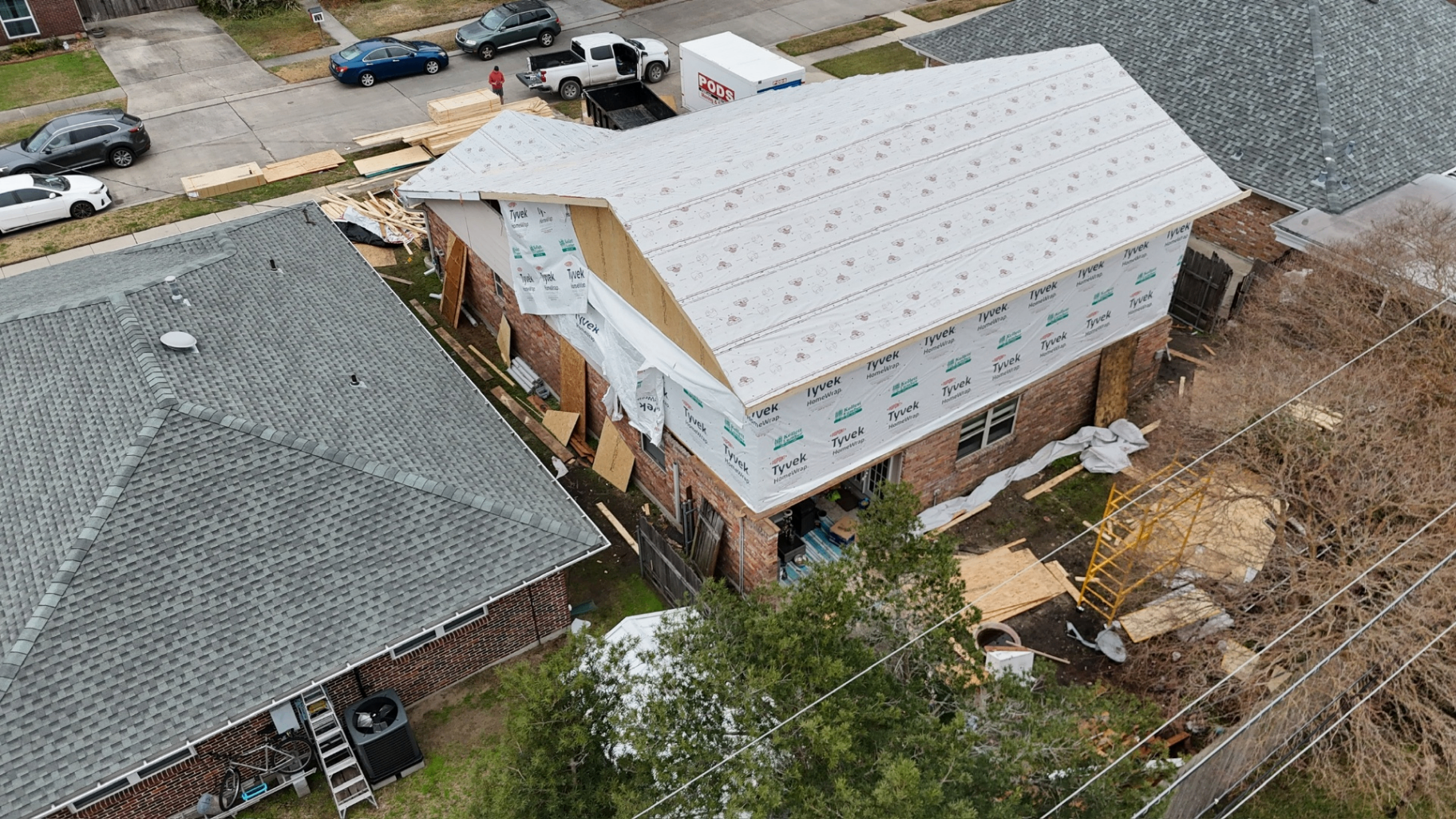 Aerial view of second-floor addition under construction with Tyvek house wrap on Bissonet Dr in Metairie, LA