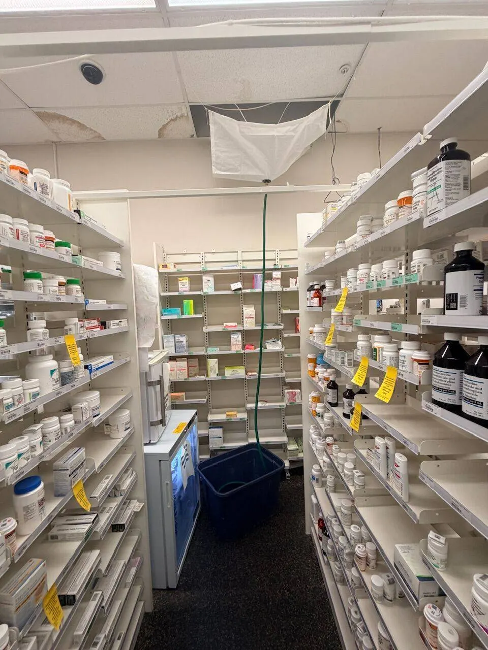 Commercial pharmacy ceiling water damage with staining and active leak requiring emergency structural repair