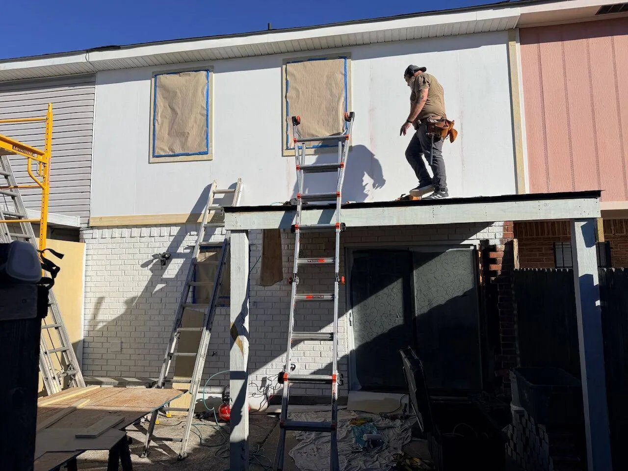 Crew performing exterior siding and painting during rental turnover preparation