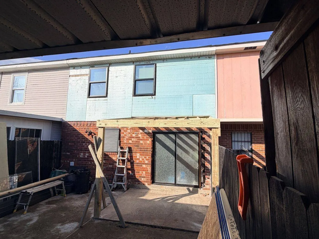 New porch installation with exterior siding fascia board and fresh paint on brick townhouse in New Orleans