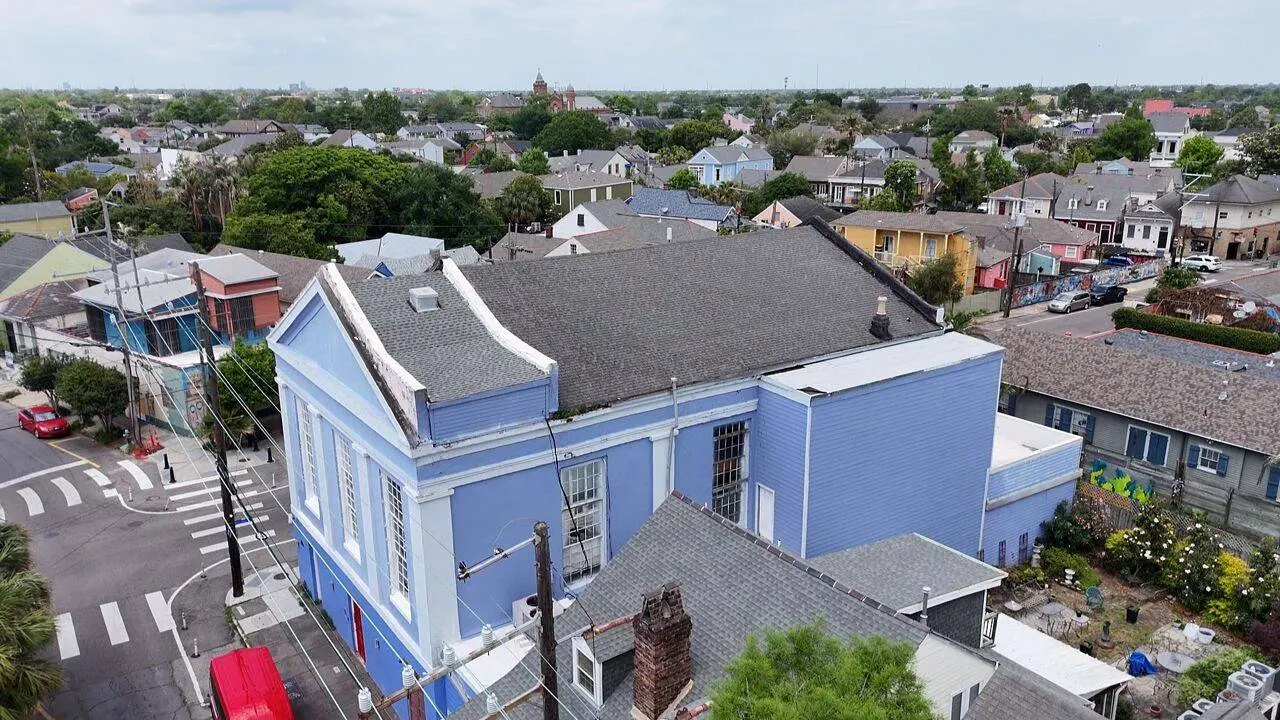 Aerial drone view of historic blue commercial building roof in New Orleans neighborhood