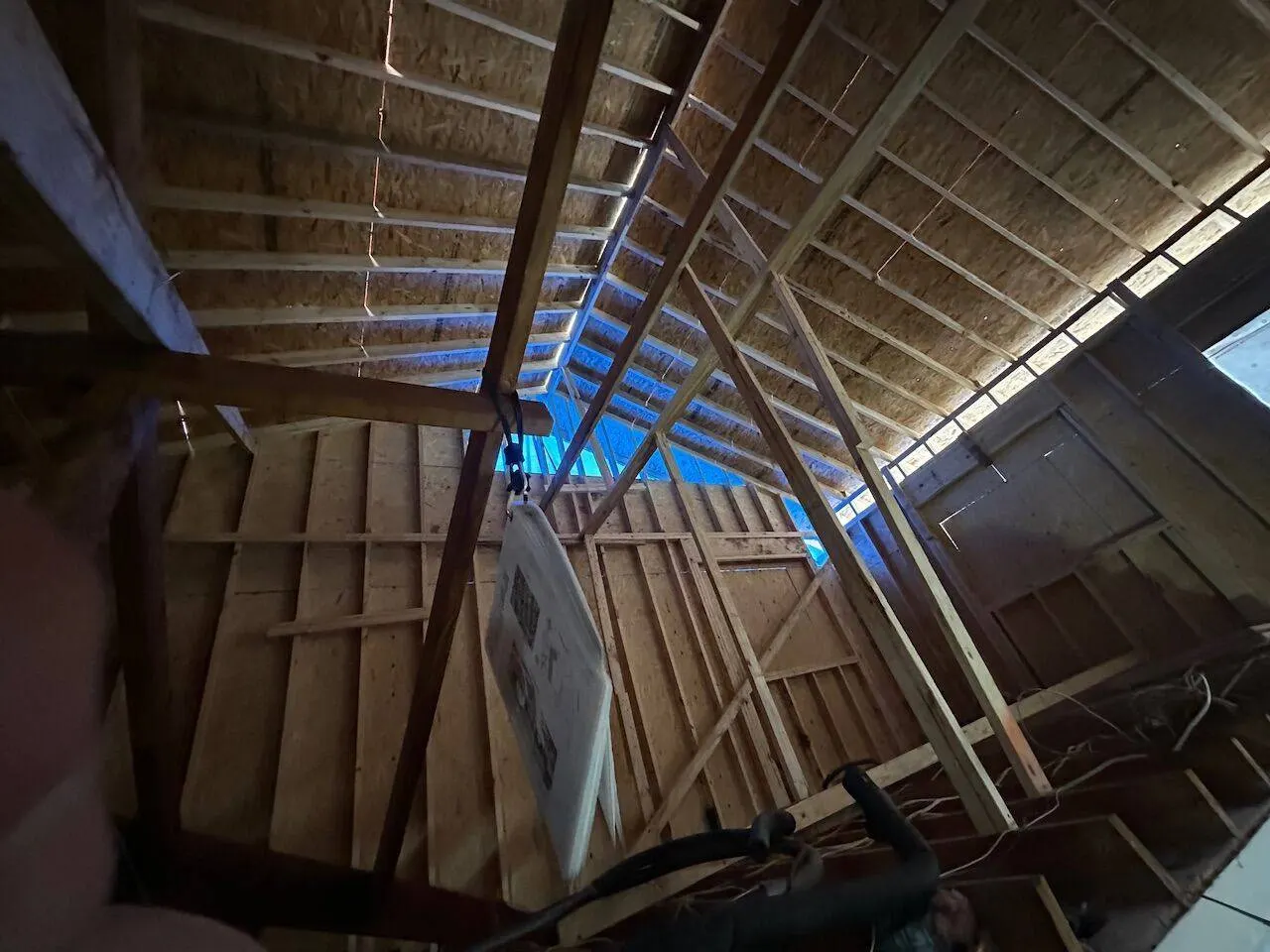 Interior view of attic rafter framing and OSB sheathing during structural roof rebuild