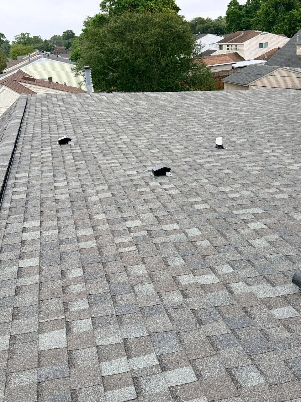 Completed architectural shingle roof with vents and plumbing boots in Louisiana residential neighborhood