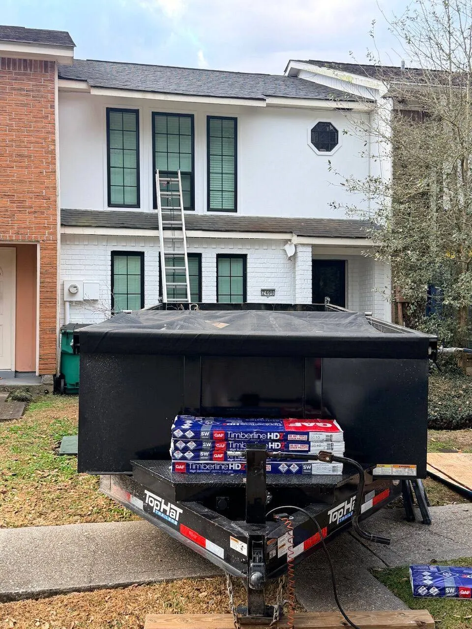 GAF Timberline HDZ shingles delivered and staged on dump trailer at townhome roofing project