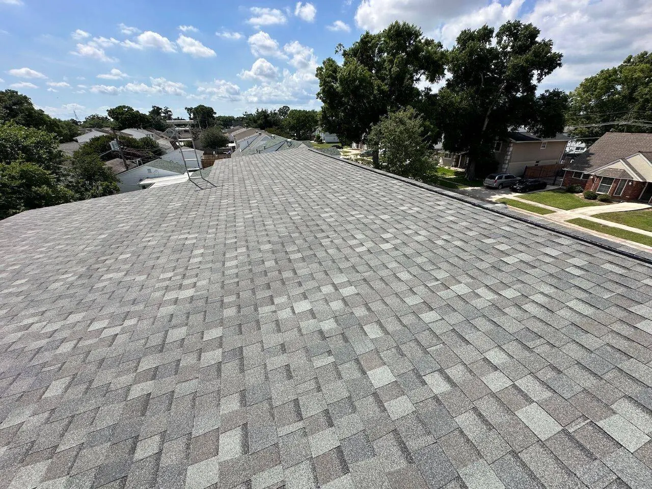 Wide angle view from roof showing completed architectural shingle installation across residential neighborhood in Metairie