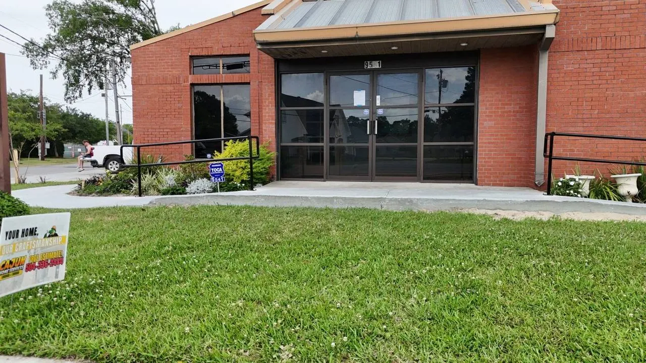 Ground-level frontal view of completed ADA ramp and handrails at Jefferson Highway facility entrance in Jefferson Parish Louisiana