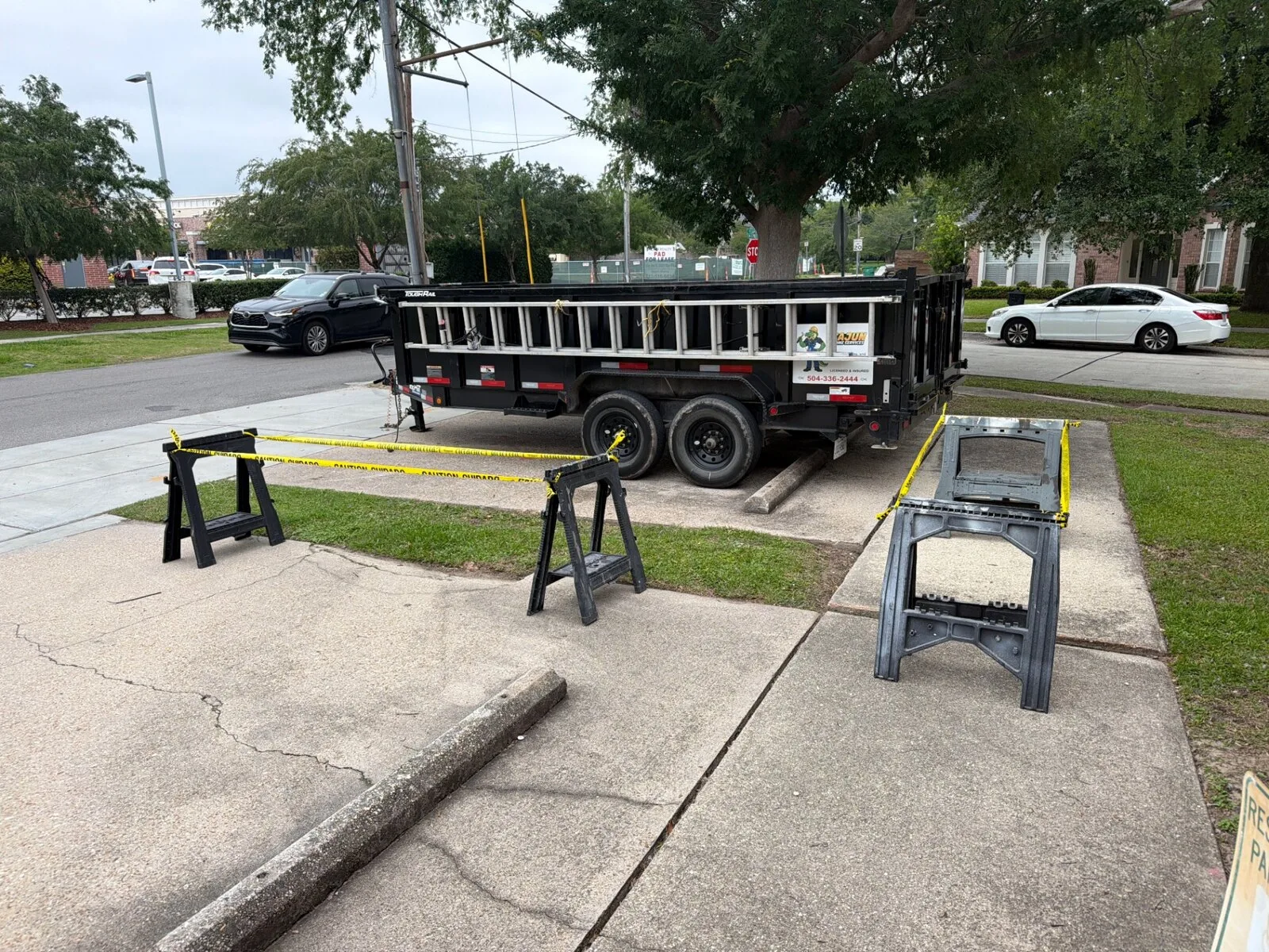 Cajun Home Services branded dump trailer staged for concrete slab haul-off on Jefferson Highway in Jefferson Parish Louisiana