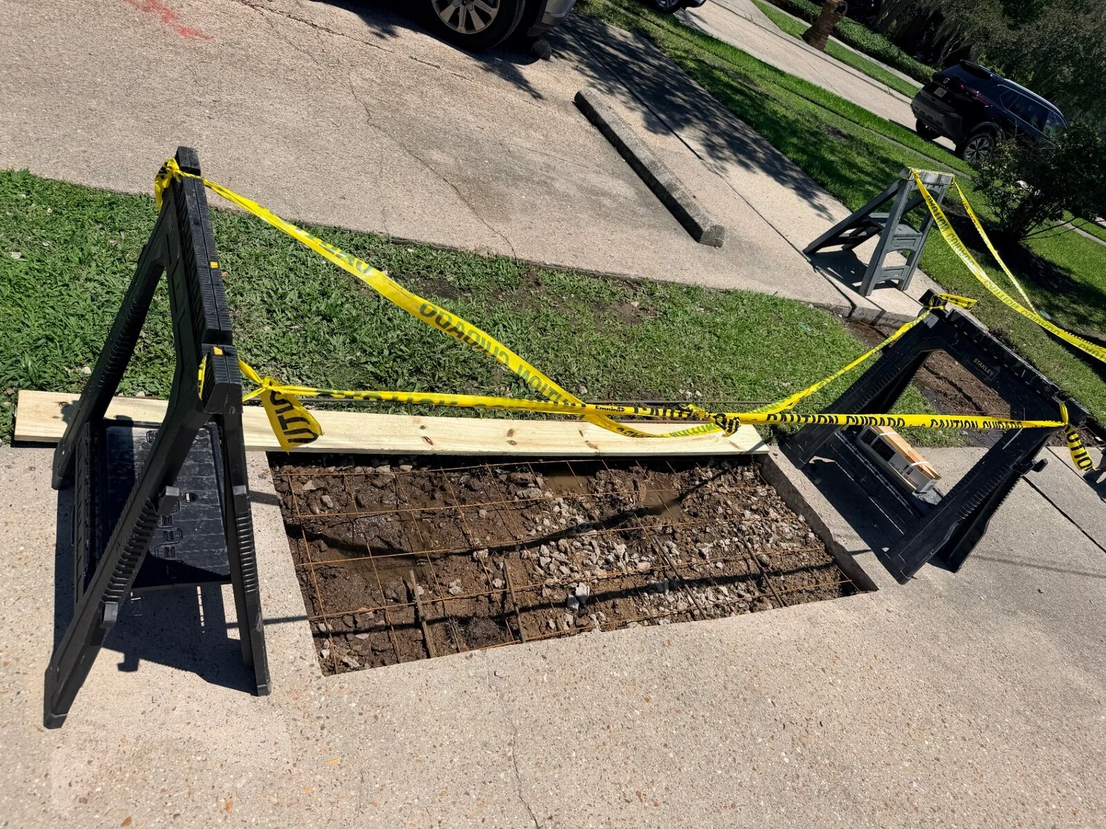 Excavated slab cavity with rebar grid and gravel base prepared for new concrete pour on Jefferson Highway in Jefferson Parish Louisiana