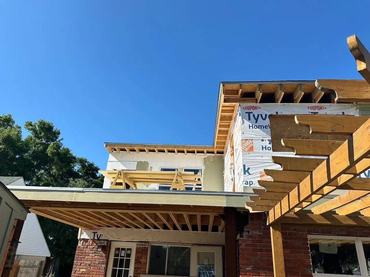 Second story addition with pergola and Tyvek wrap progress in Metairie