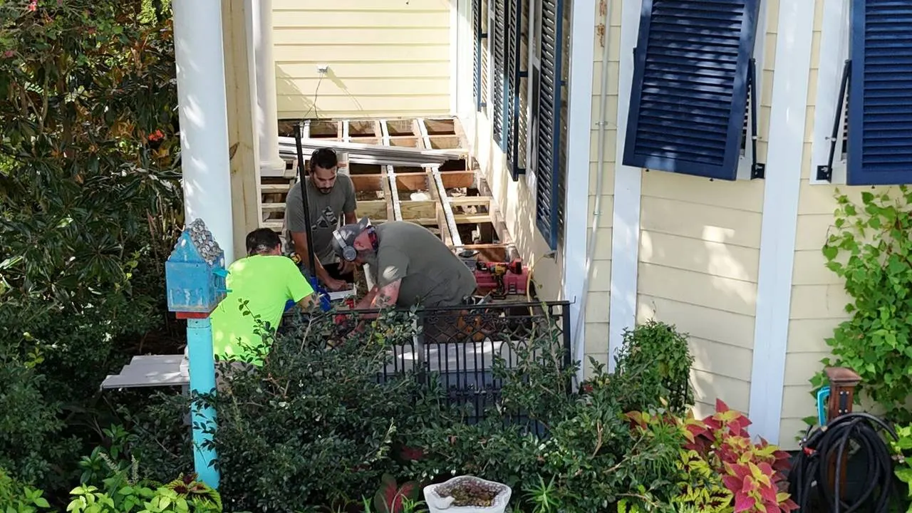 Construction crew installing deck framing on historic home porch in Algiers Point
