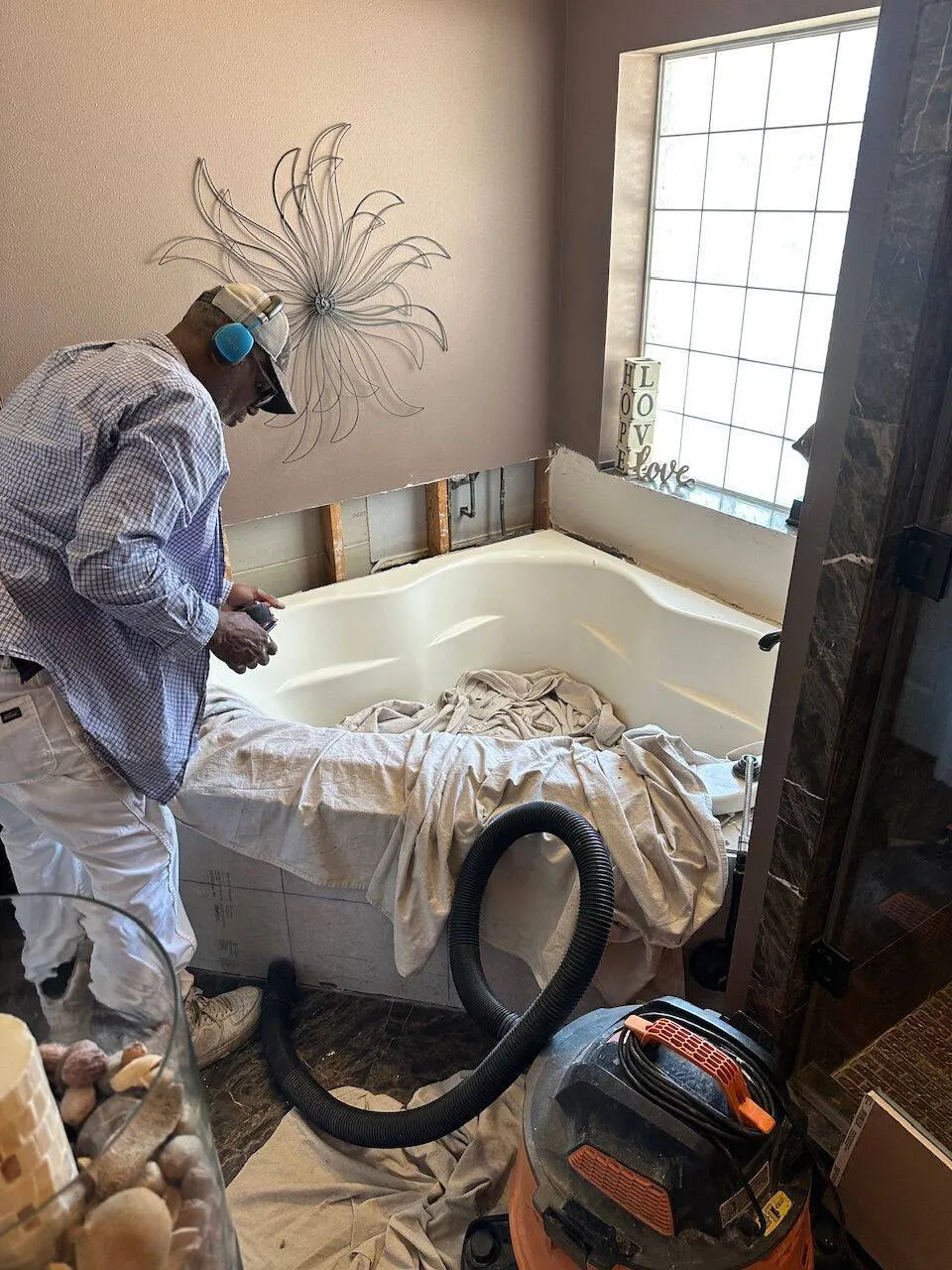 Crew member repairing tub surround tile in Kenner LA