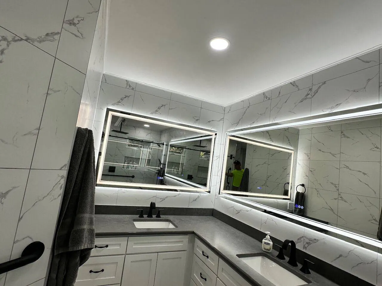 Finished master bathroom wide view with dual LED vanity mirrors and marble in Metairie Louisiana