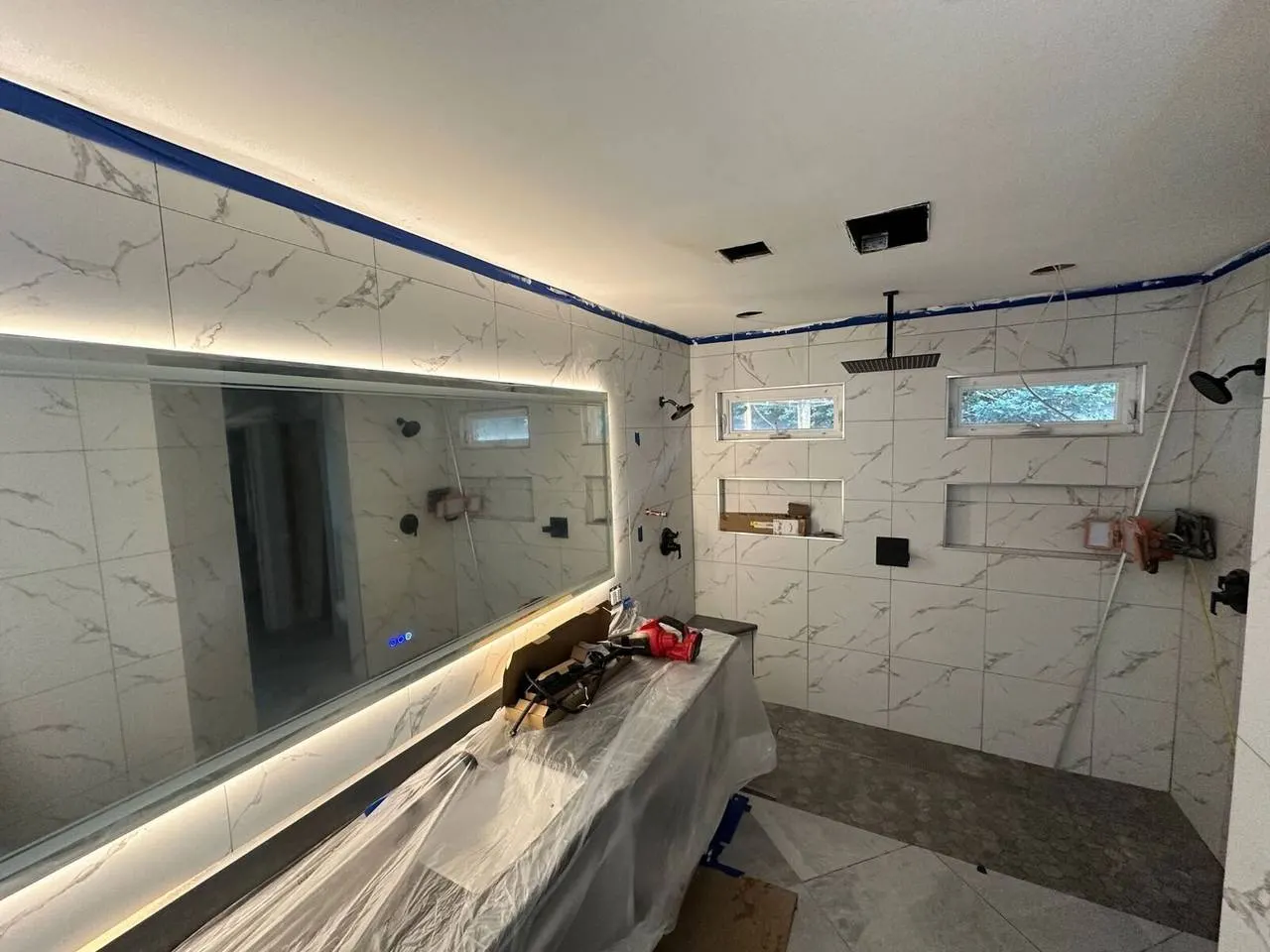 Custom marble tile bathroom remodel with LED mirror and rain shower in New Orleans Louisiana