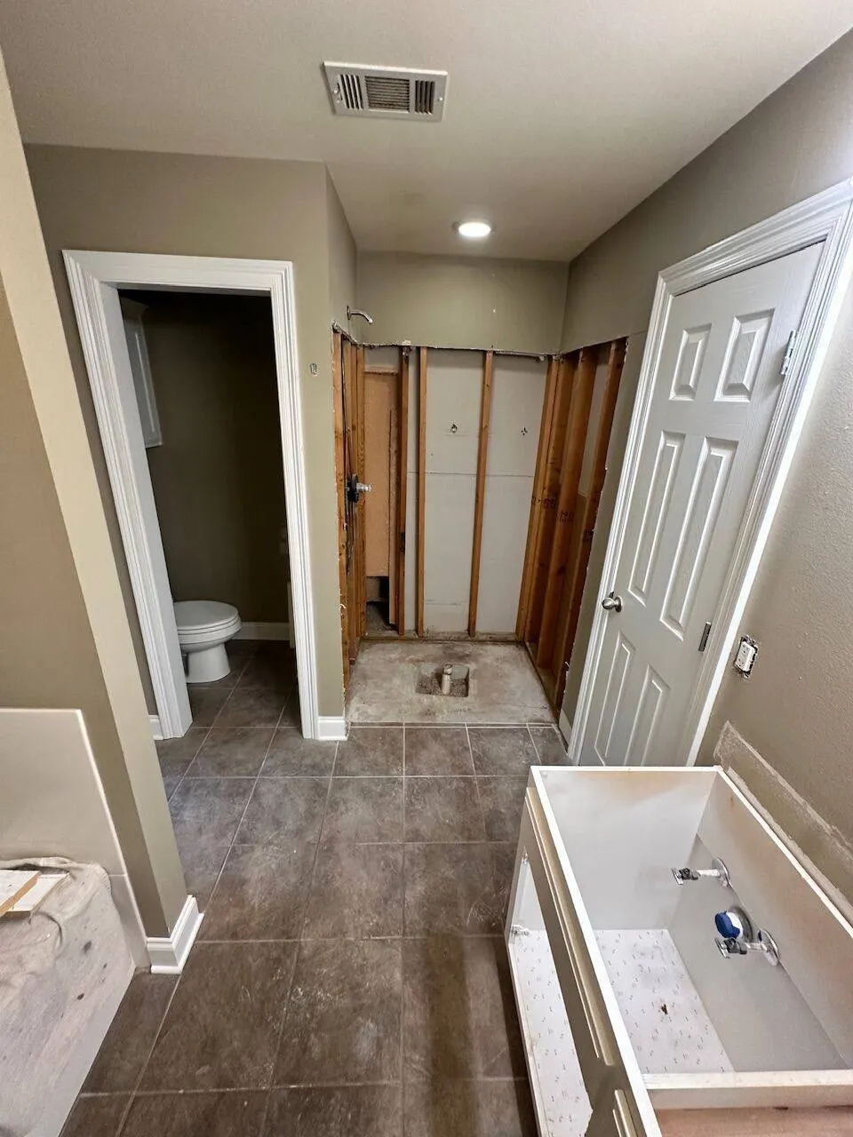 Bathroom shower demo with exposed framing during Gonzales renovation