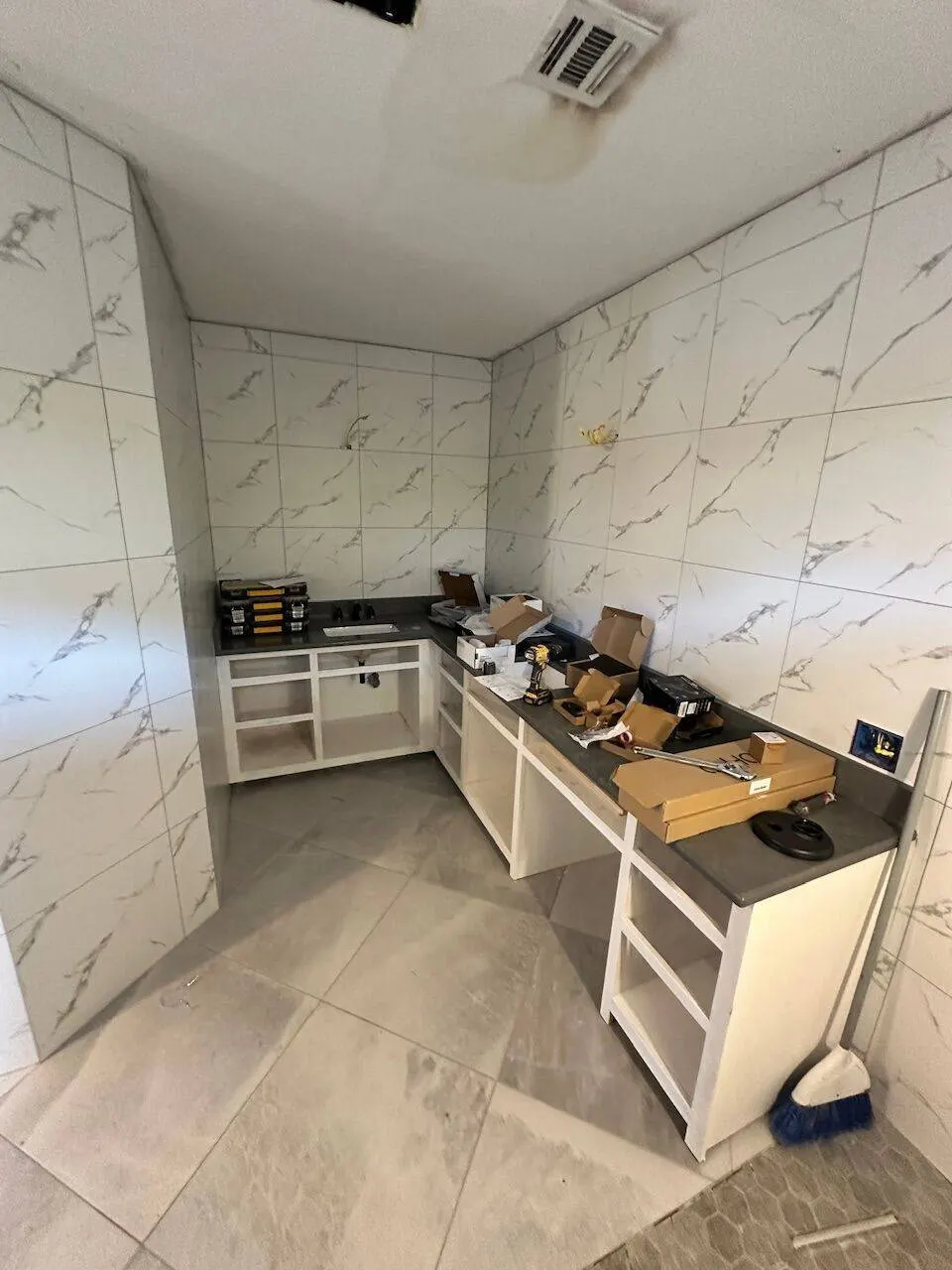 Bathroom vanity and marble wall tile installation in progress during full remodel
