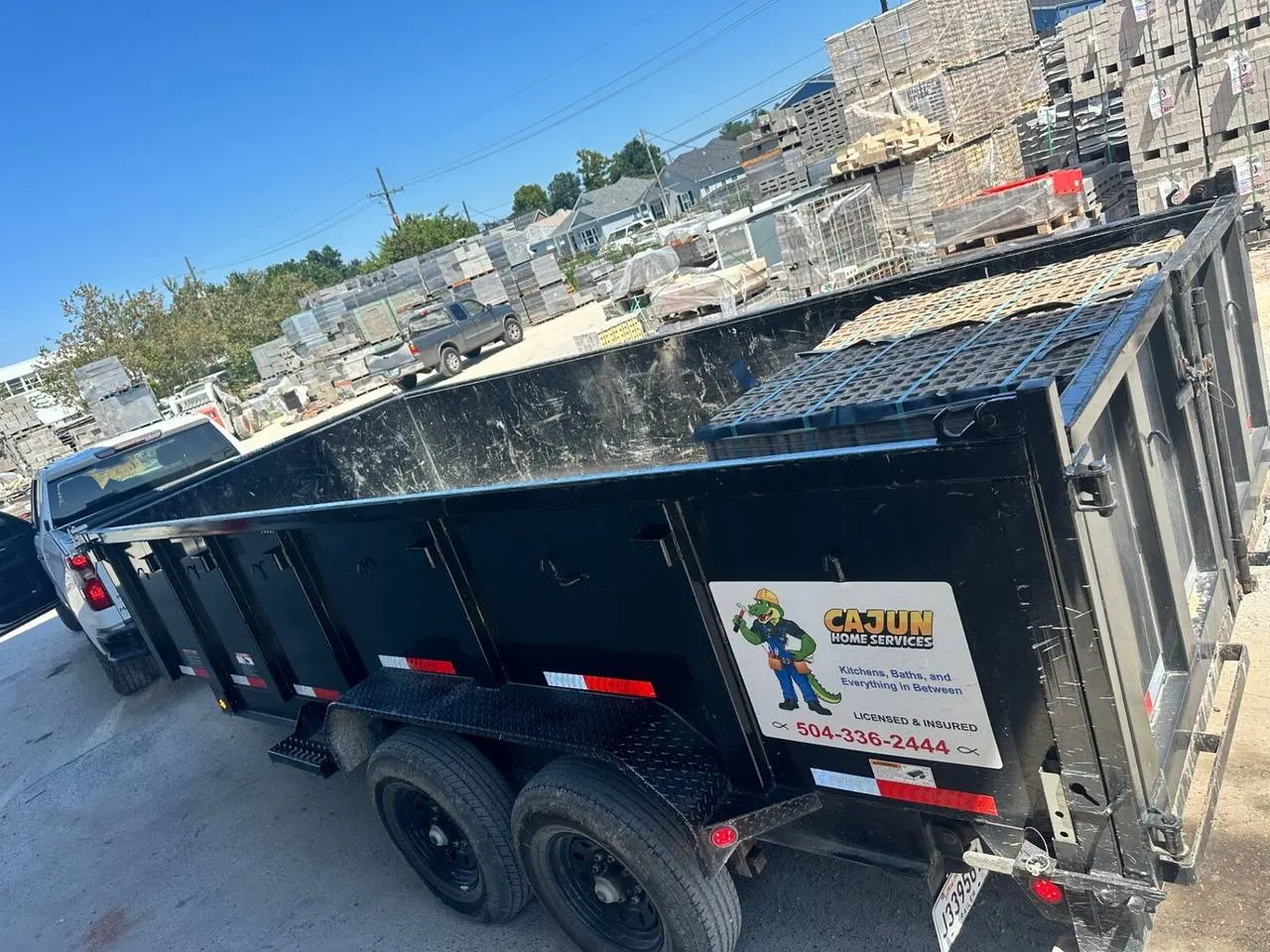 Cajun Home Services branded dump trailer at supply yard in Metairie Louisiana