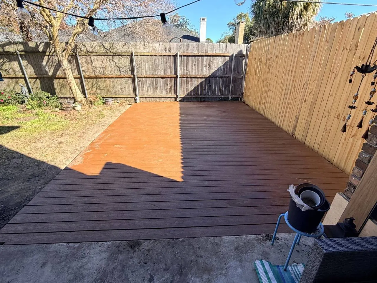 Completed two-tone composite deck with brown and tan decking in Metairie backyard