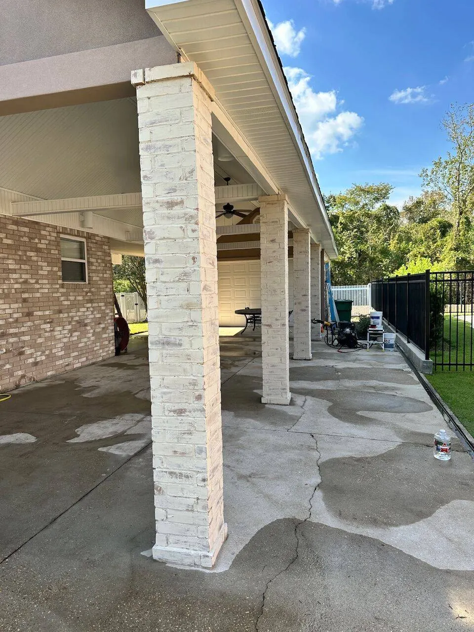 Completed covered patio with brick columns soffit ceiling and ceiling fan in Kenner LA