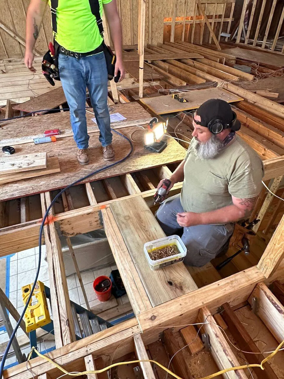 Crew installing floor framing and subfloor on second floor addition in Metairie