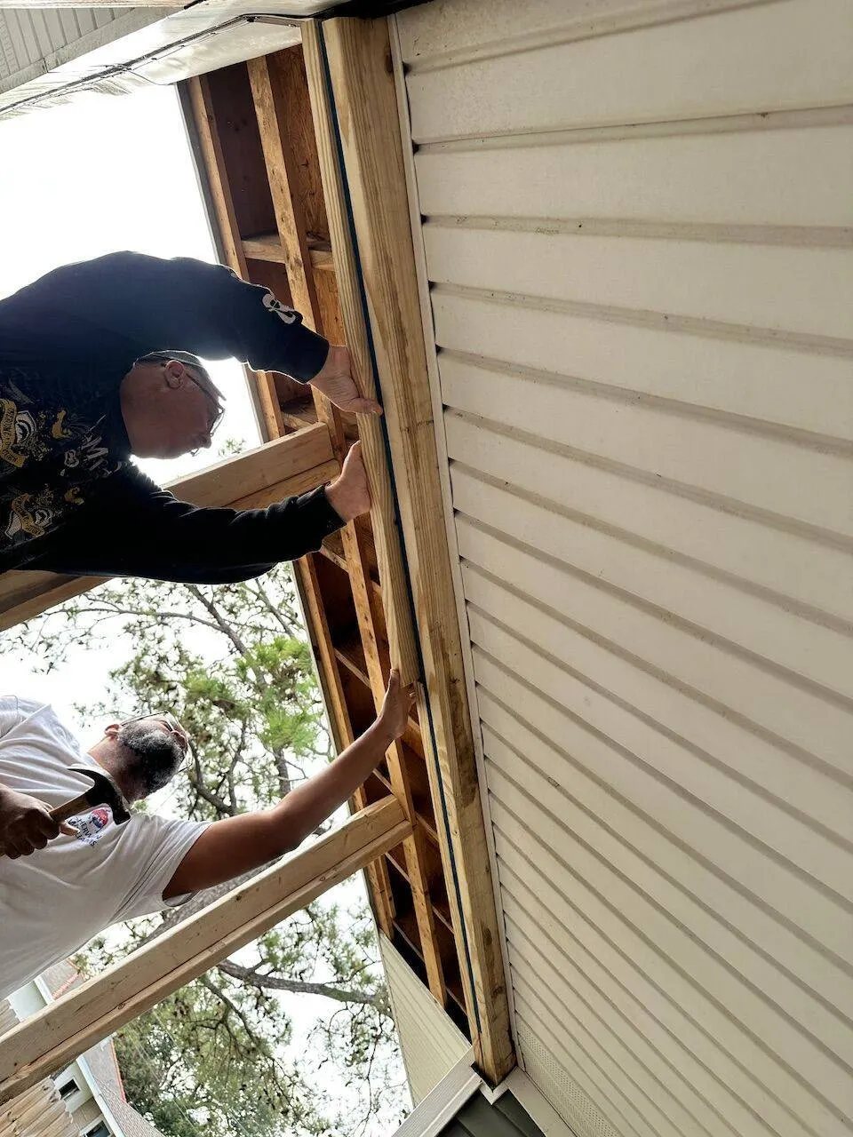 Crew framing exterior wall before siding installation