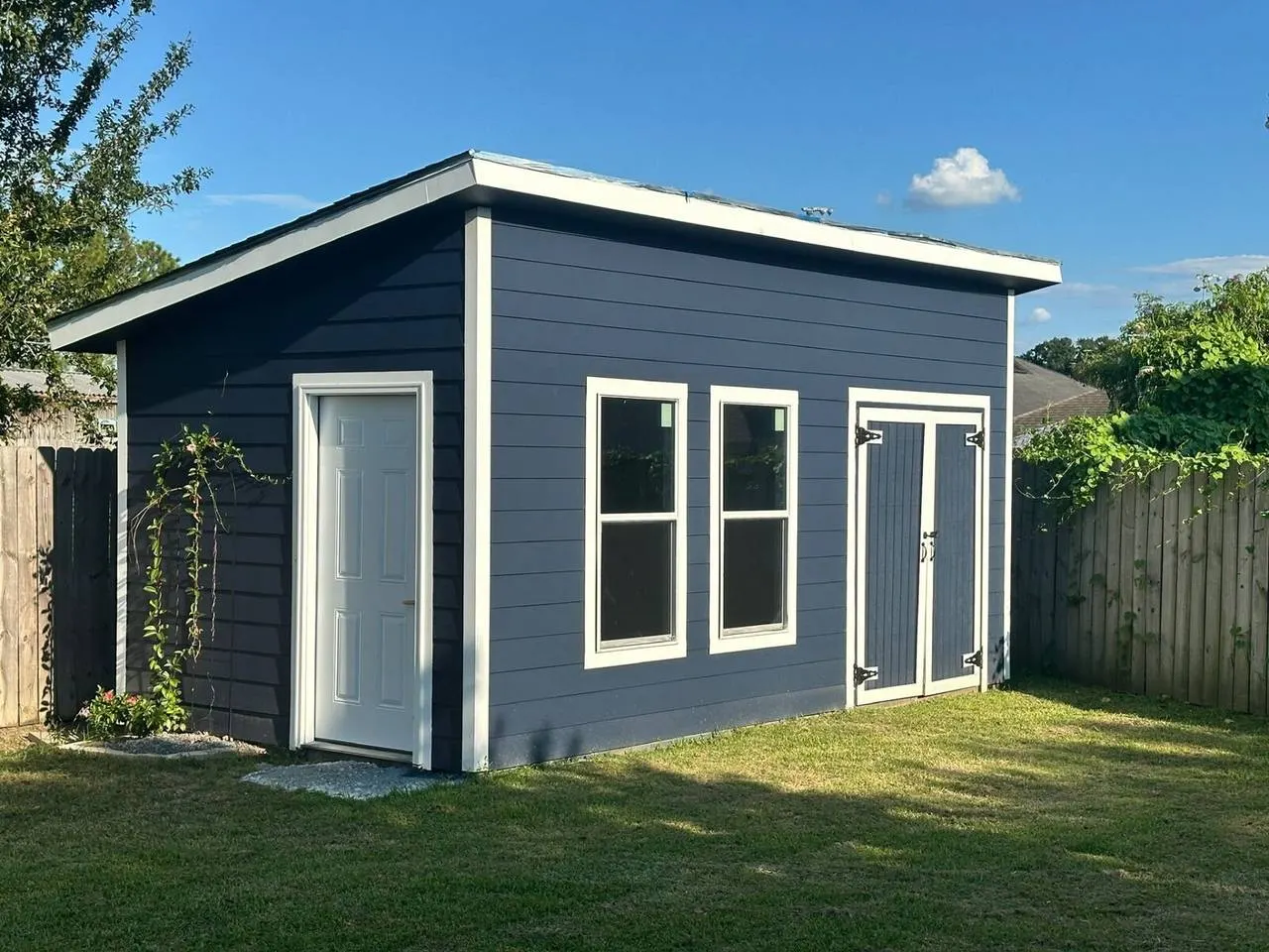 Custom backyard shed with gray siding and white trim in Metairie LA
