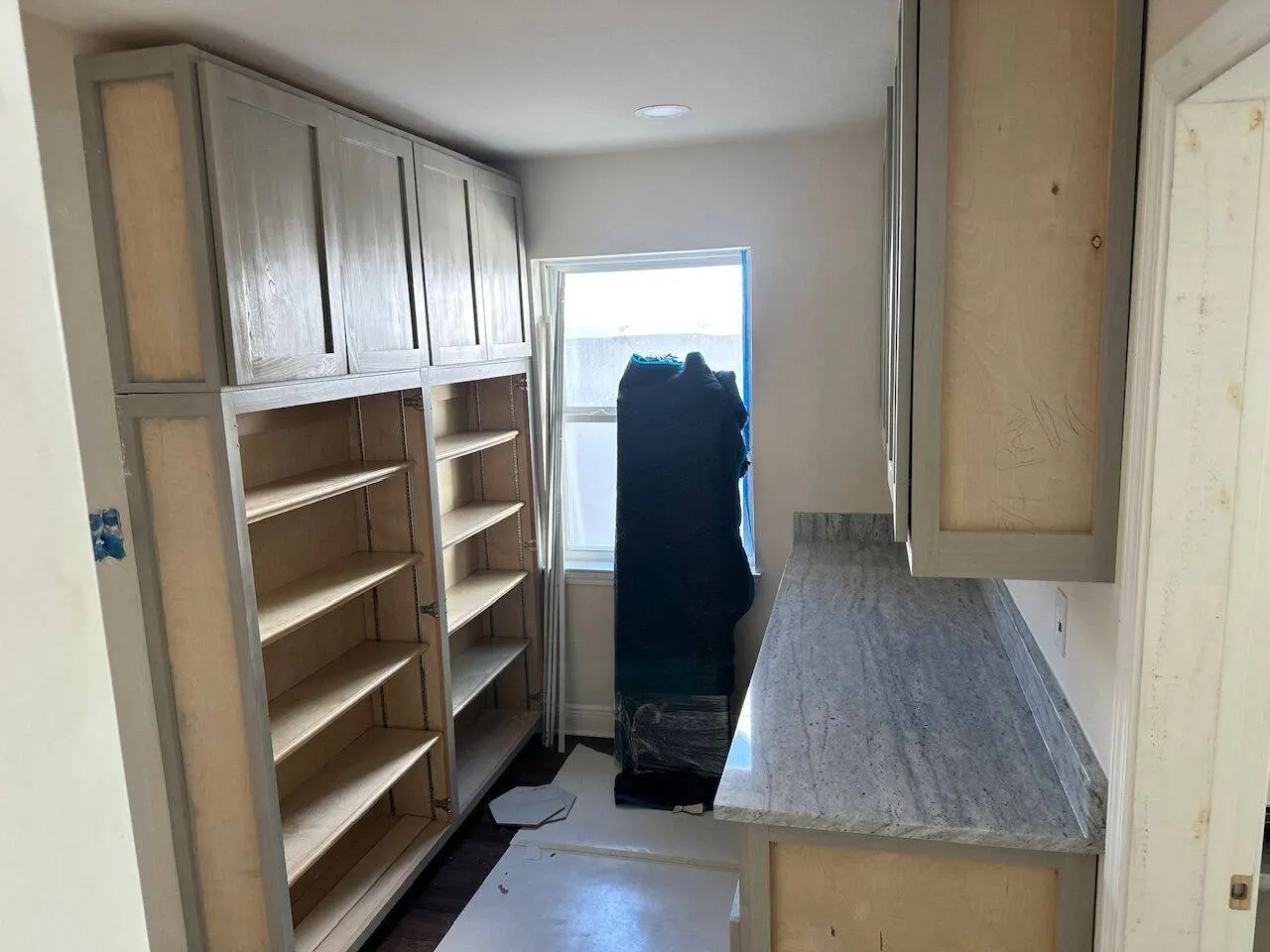 Custom kitchen cabinetry with open shelving and granite countertops by Cajun Home Services