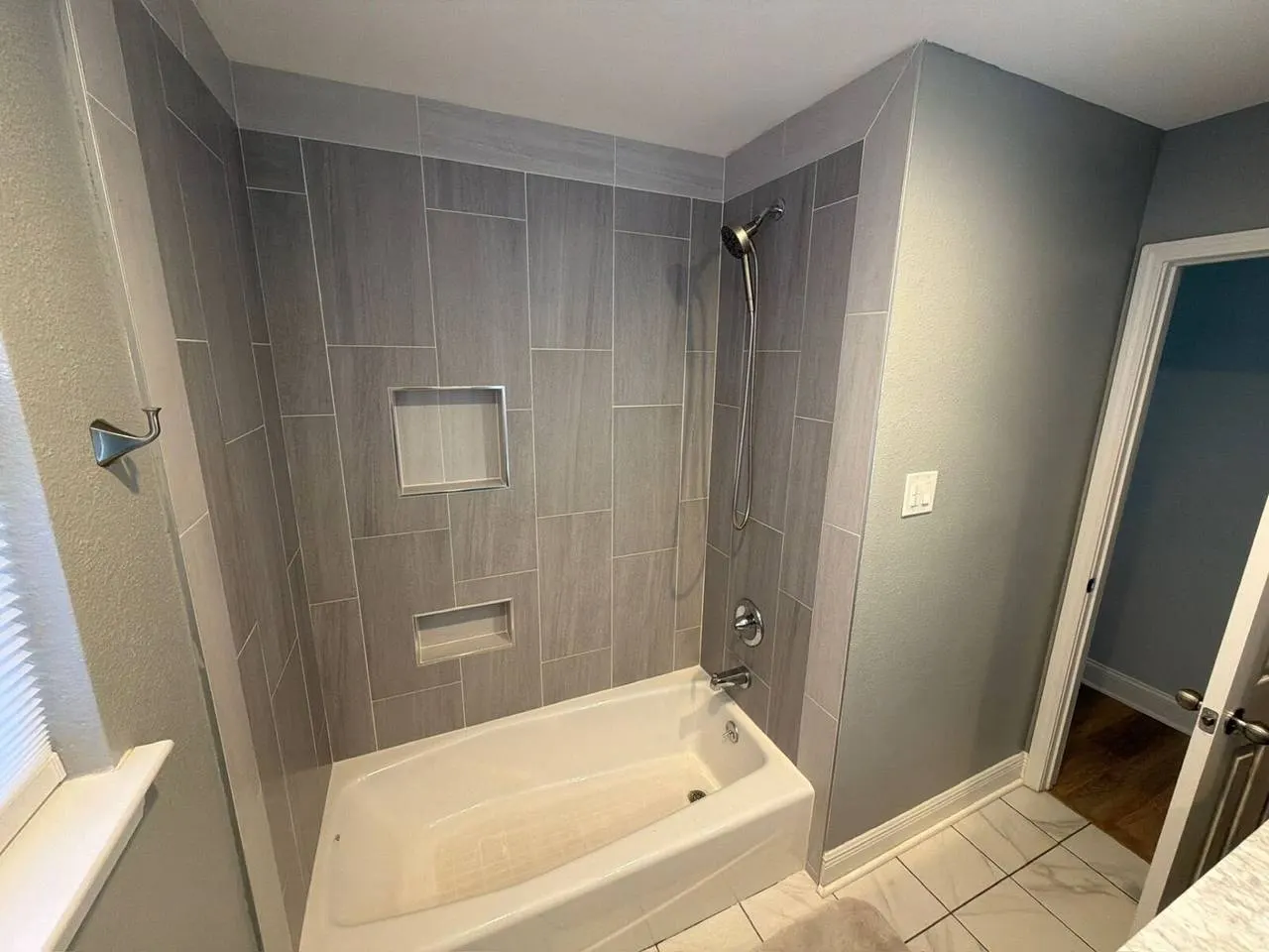 Custom tile shower with built-in niches and gray wood-look tile in Metairie LA