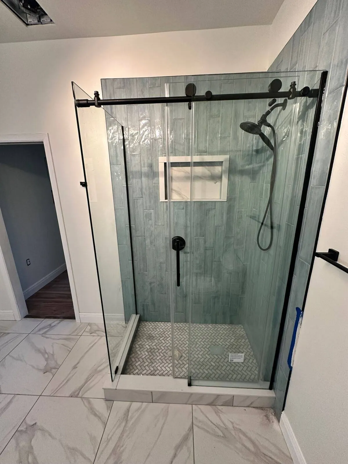 Custom tile shower remodel with accent tile wall and glass enclosure in Metairie LA