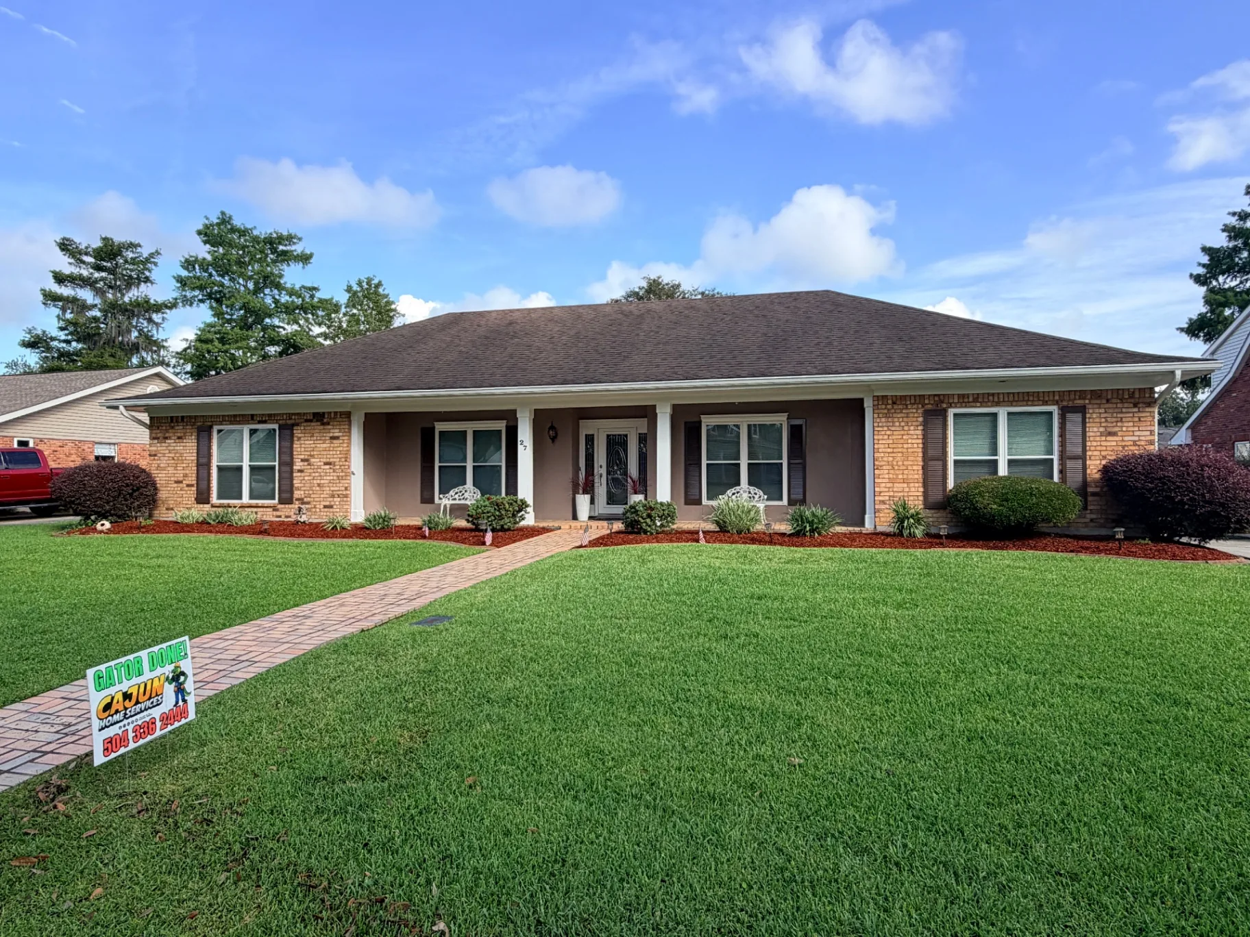 Completed shutter replacement on Destrehan brick home with Cajun Home Services yard sign