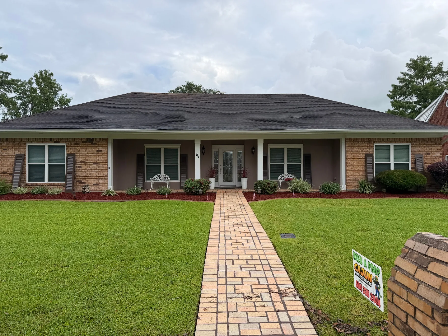 Front elevation of Destrehan brick home with all new exterior shutters installed by Cajun Home Services