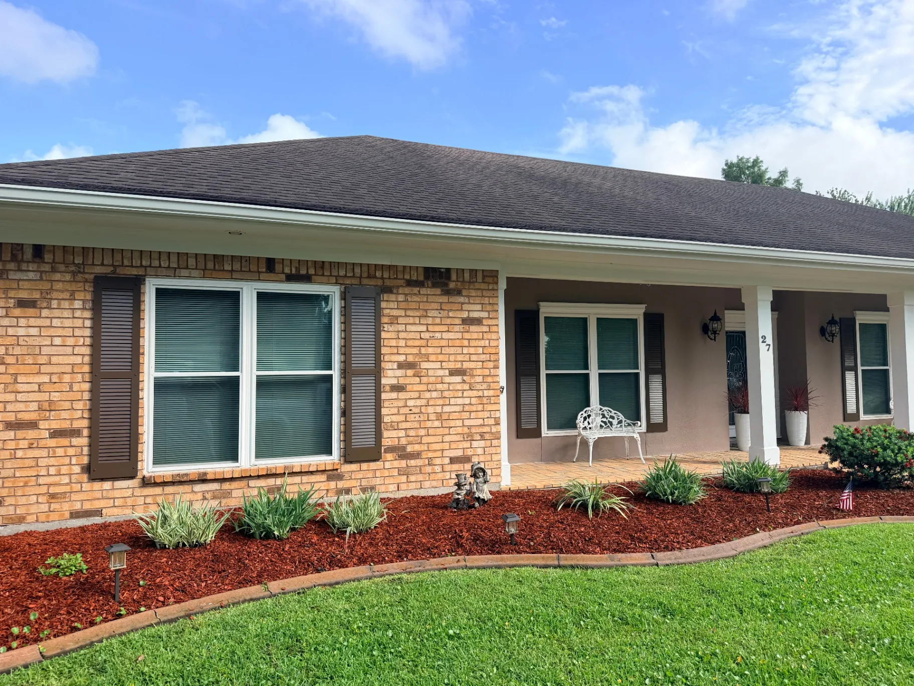 New hand-painted shutters installed on front porch windows of Destrehan Louisiana brick home